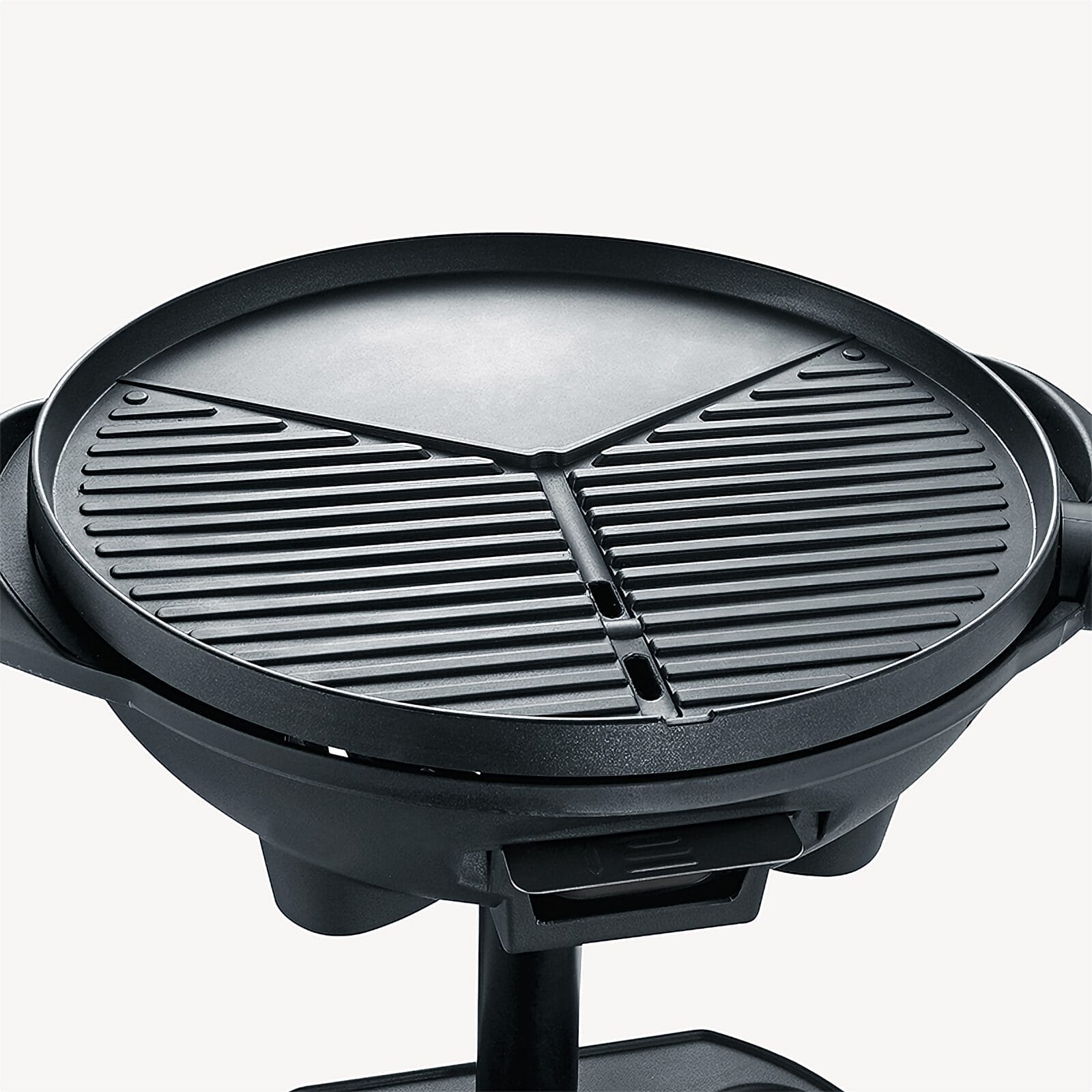 A round, black contact grill with a ribbed and a flat surface.