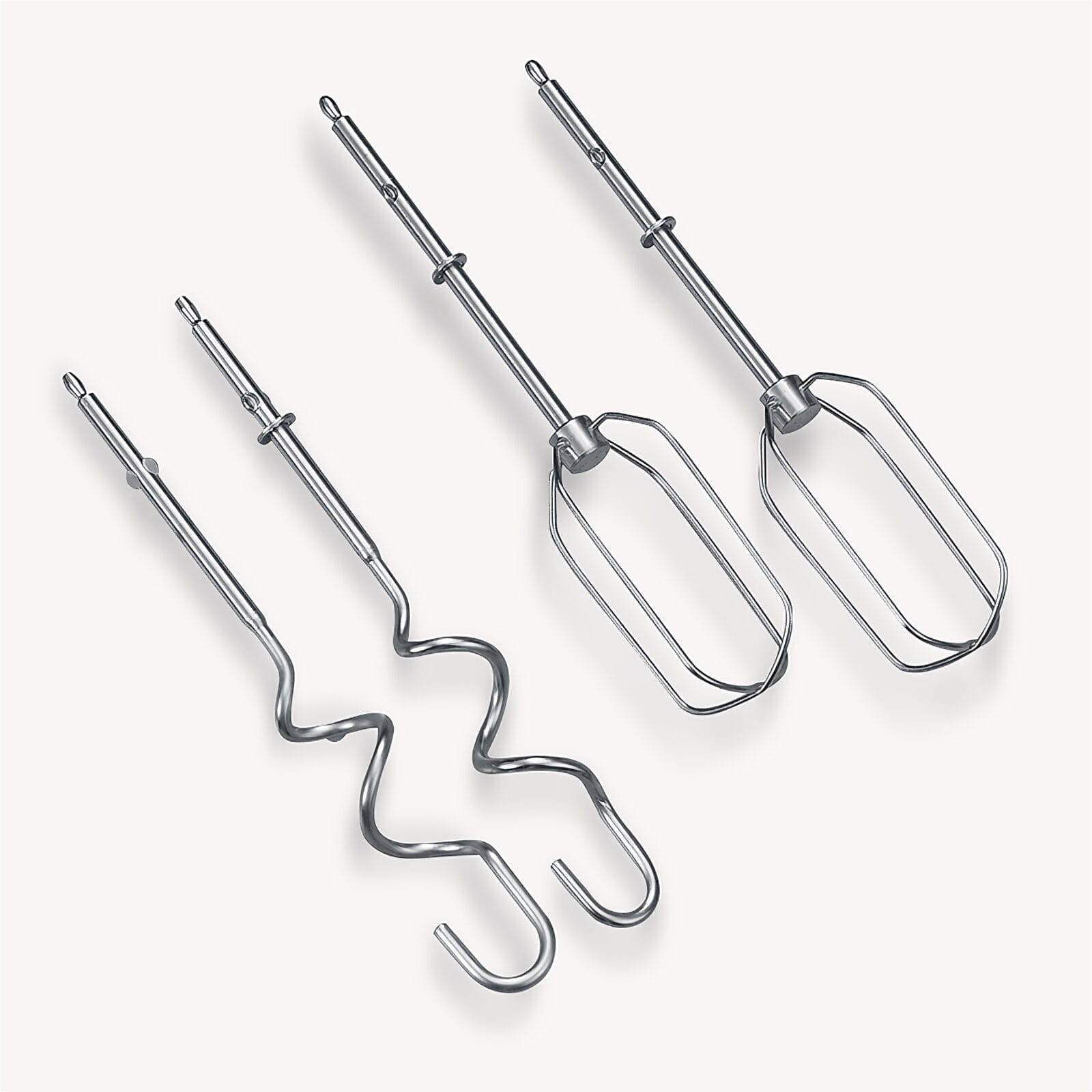 Drei metallische Rührbesen für einen Handmixer auf weißem Hintergrund.