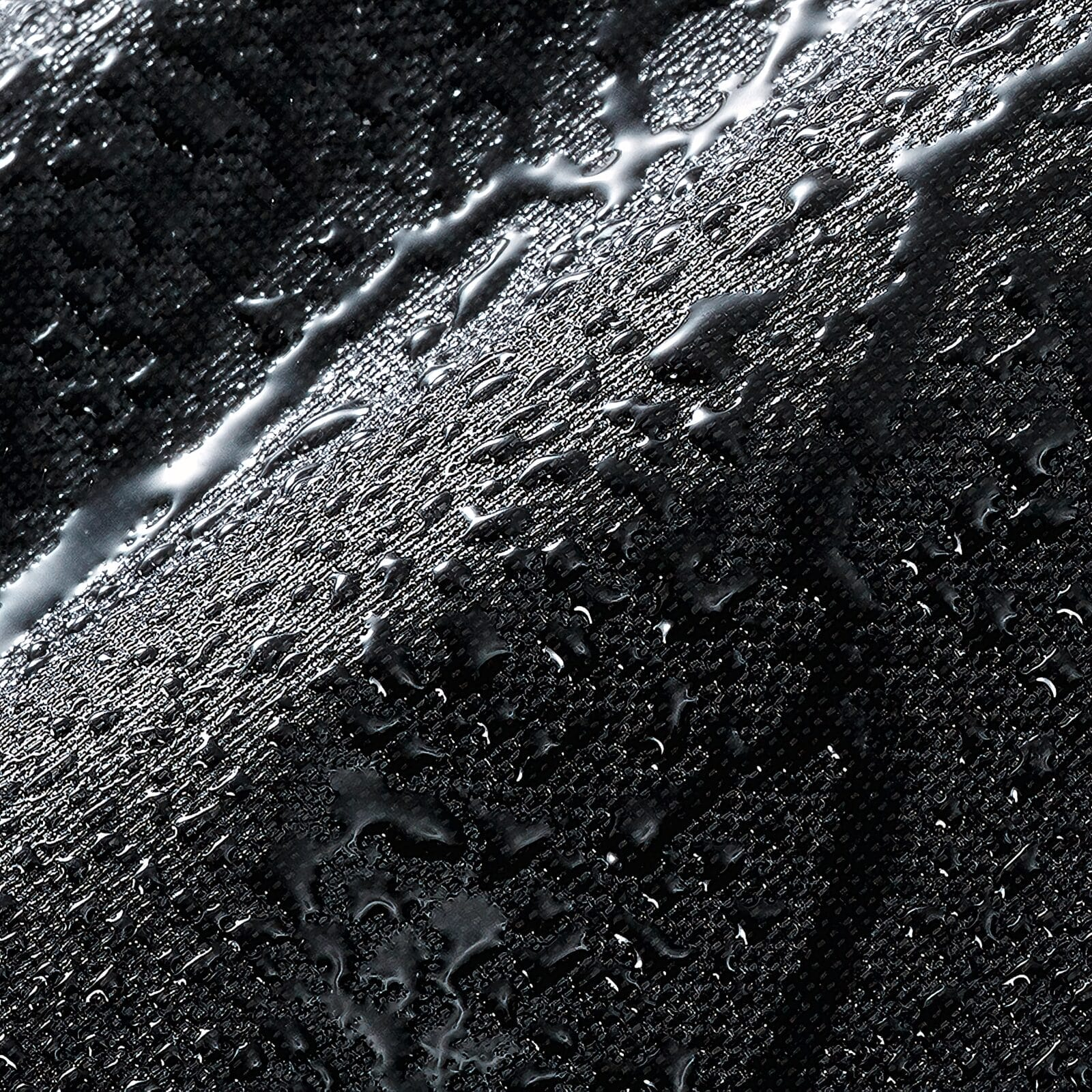 Krople wody na teksturowanej czarnej tkaninie.