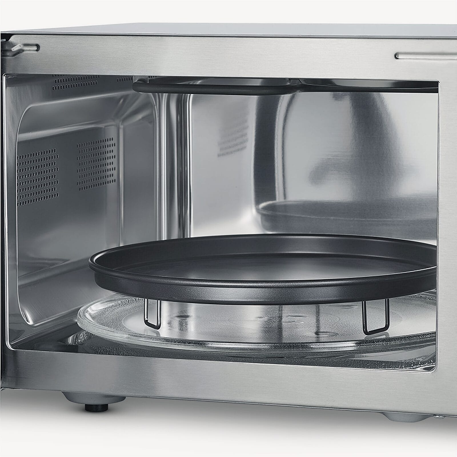 Wnętrze kuchenki mikrofalowej z obrotowym rusztem i szklanym talerzem.