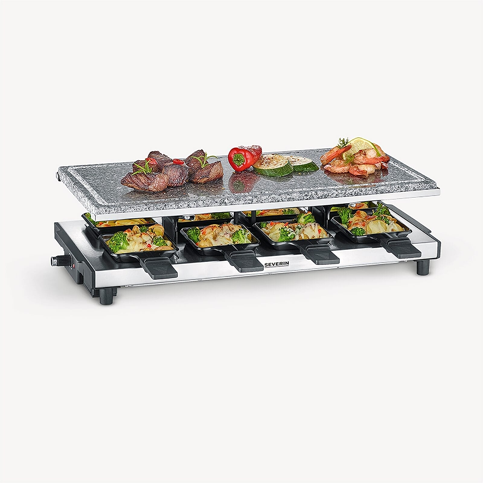 A raclette grill with meat, shrimp, and vegetables on a stone plate and pans.