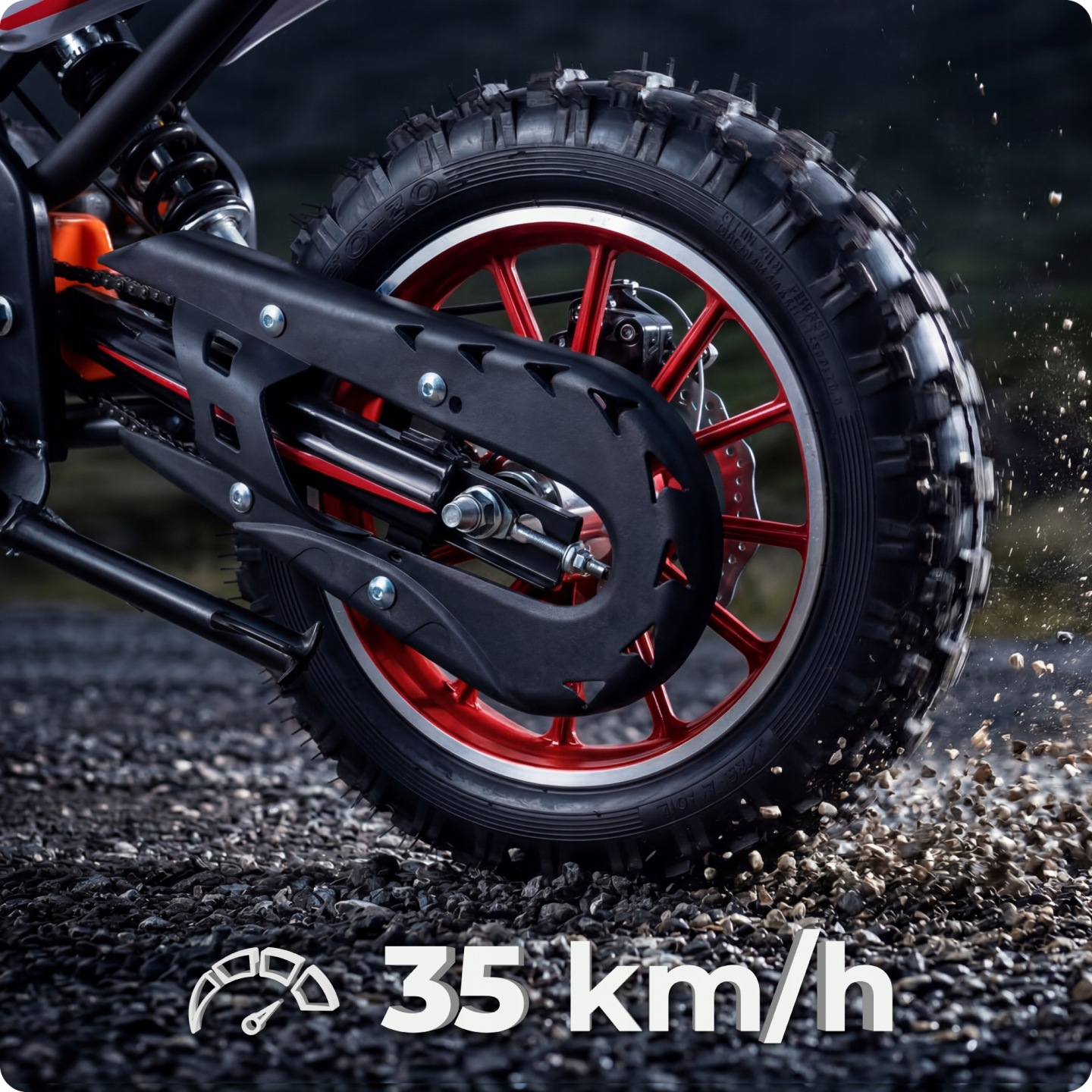 Zbliżenie tylnego koła motocykla na żwirze, wskazanie 35 km/h.