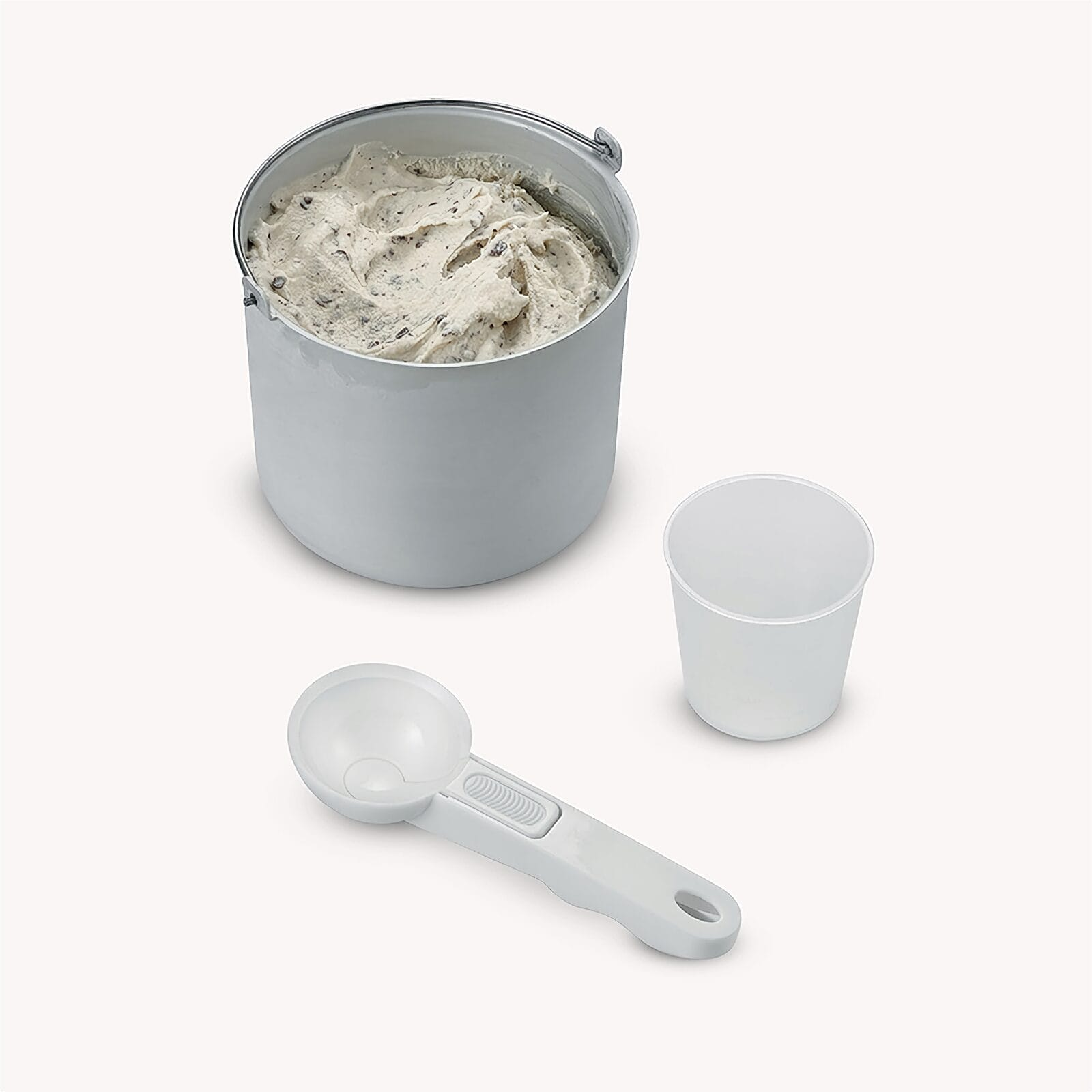 Un recipiente blanco con helado, una cuchara y una taza.