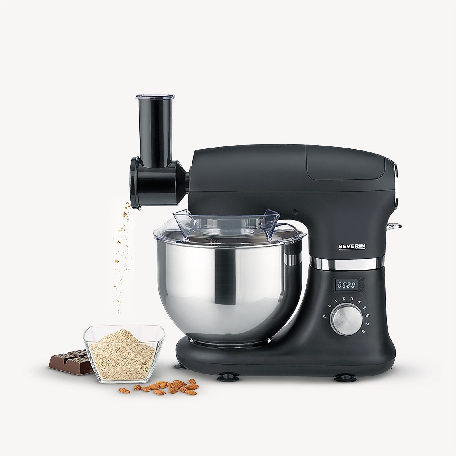 Schwarze Küchenmaschine mit silberner Schüssel, mahlt Zutaten in Schüssel.