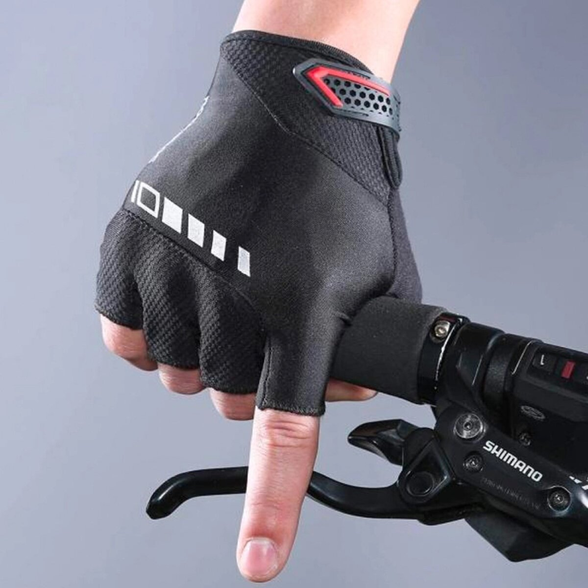 Hand in schwarzer Radsporthandschuh greift Fahrradbremse mit Shimano-Schaltung.