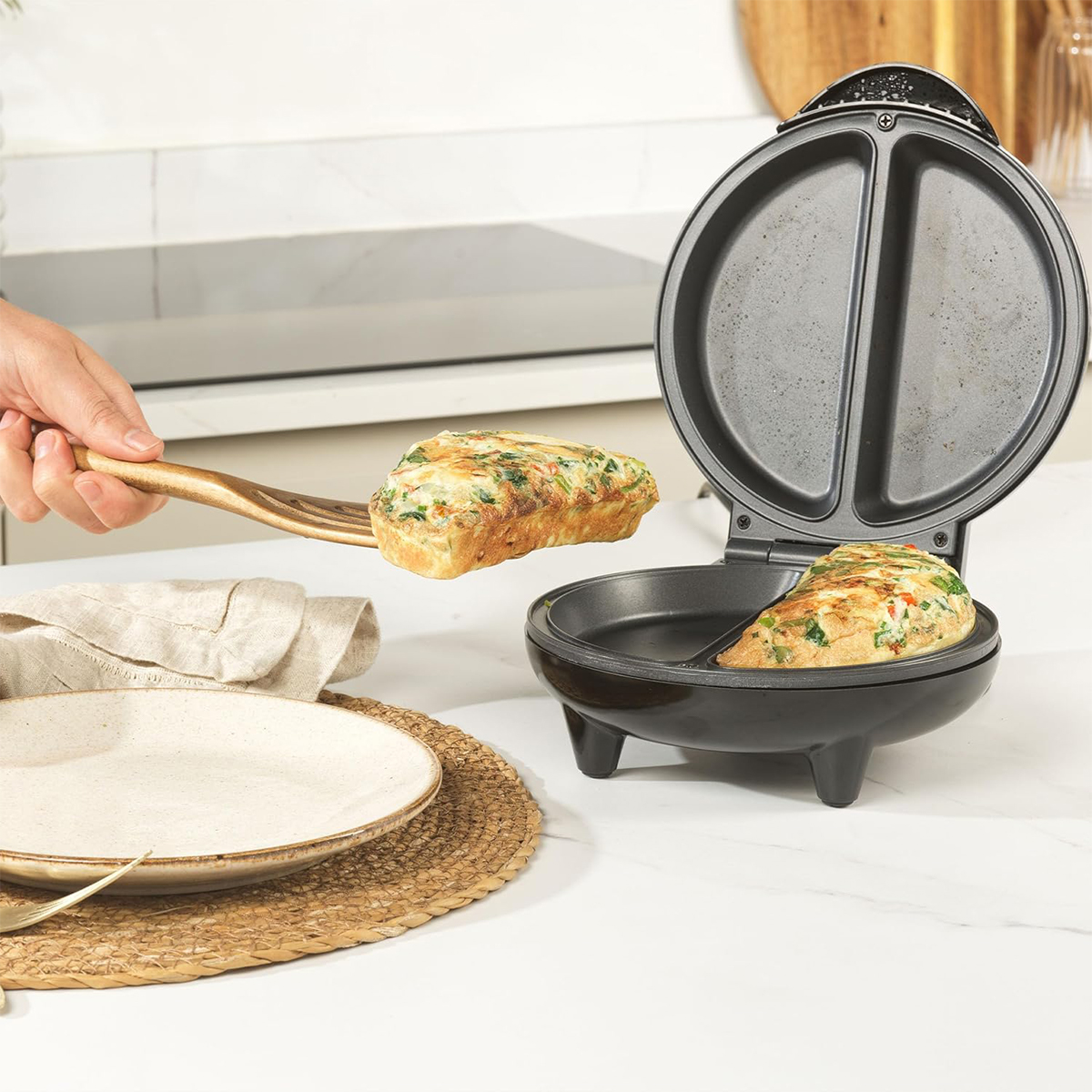 Omlet jest wyjmowany z podzielonej kuchenki. Kolejny omlet znajduje się w kuchence.