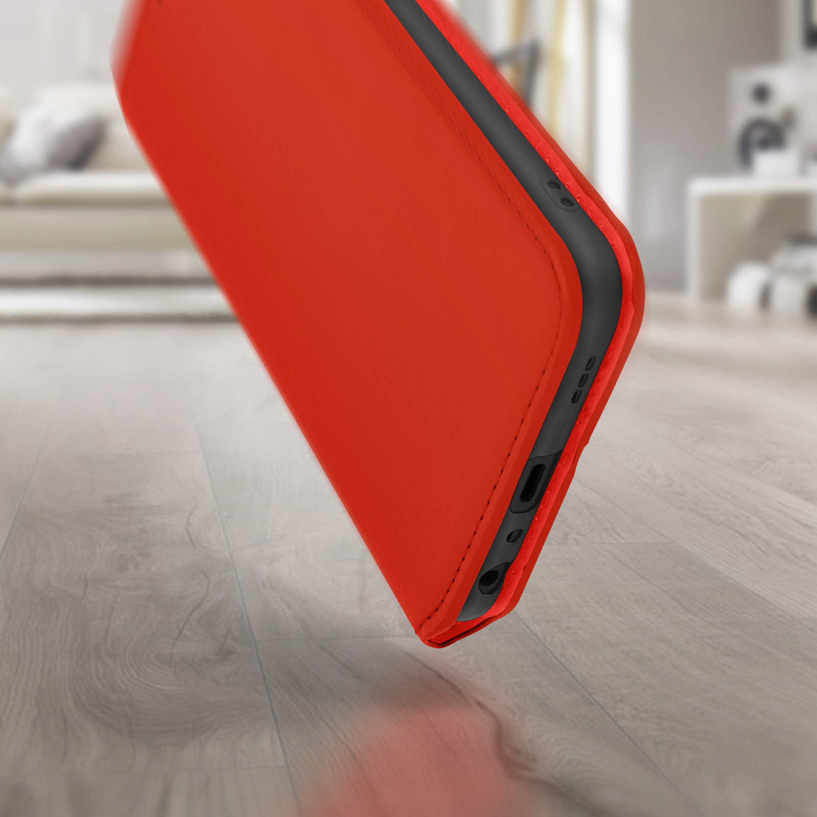 Rode telefoonhoes met zwarte knoppen op houten vloer.