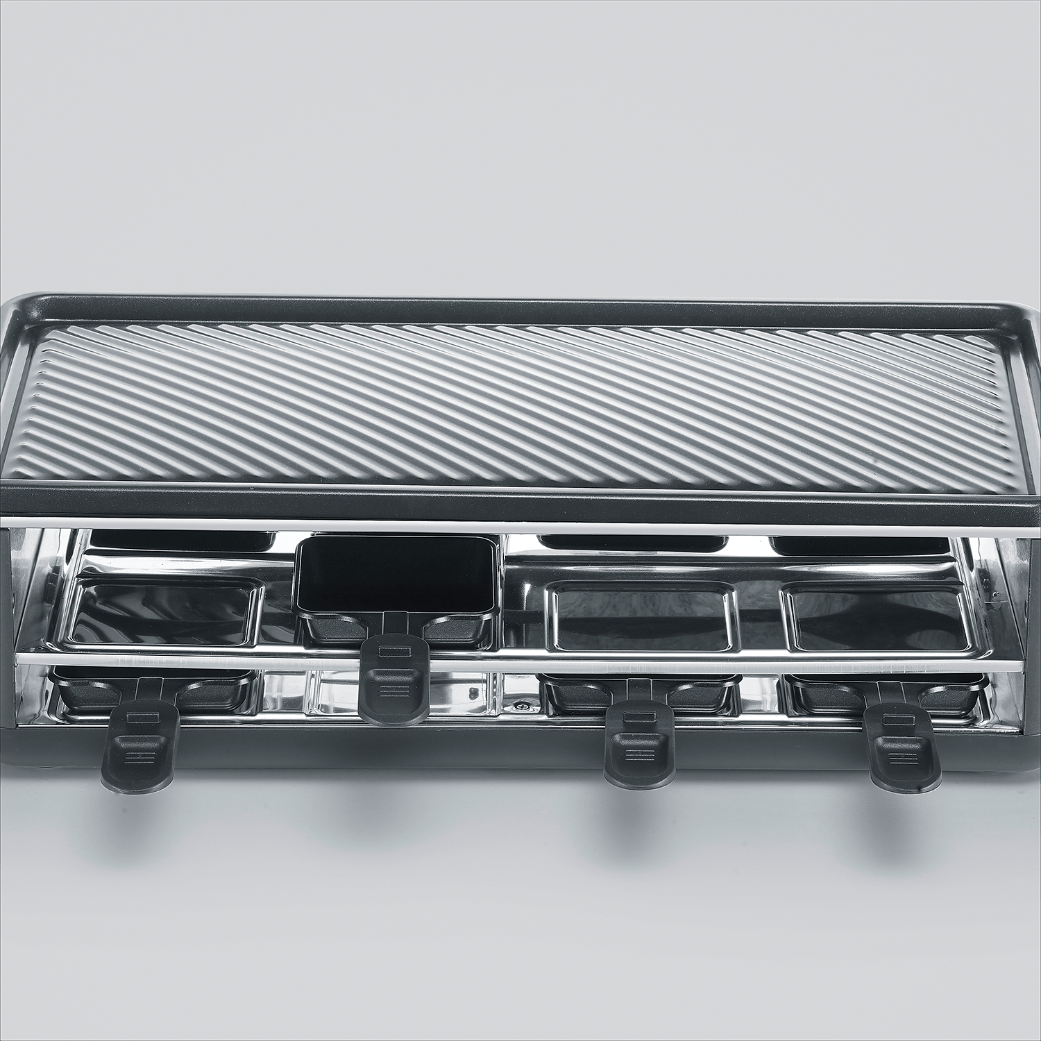 Grill z wieloma miejscami na patelnie do raclette.