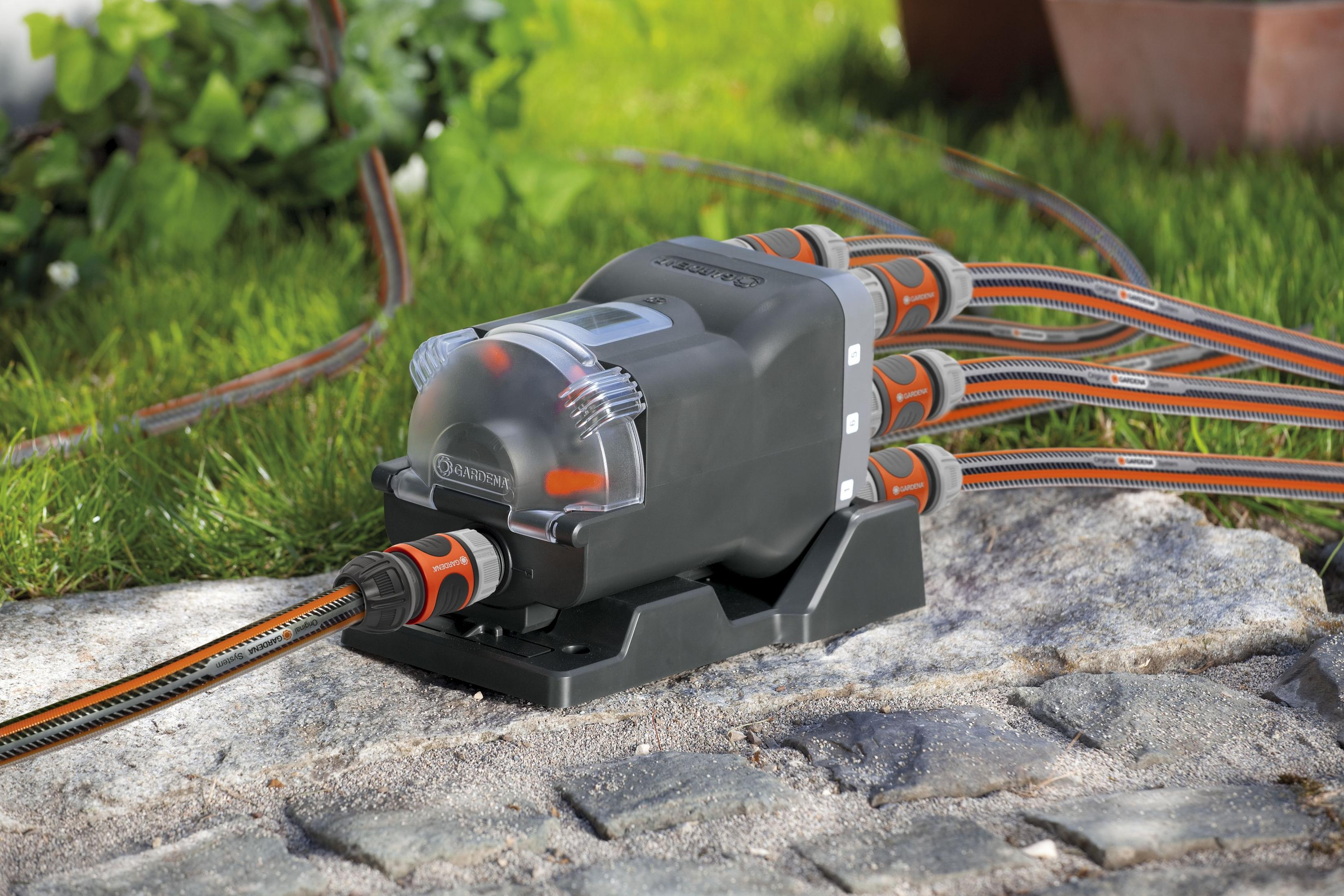 Ein GARDENA Bewässerungscomputer mit vier Ausgängen auf Steinen.