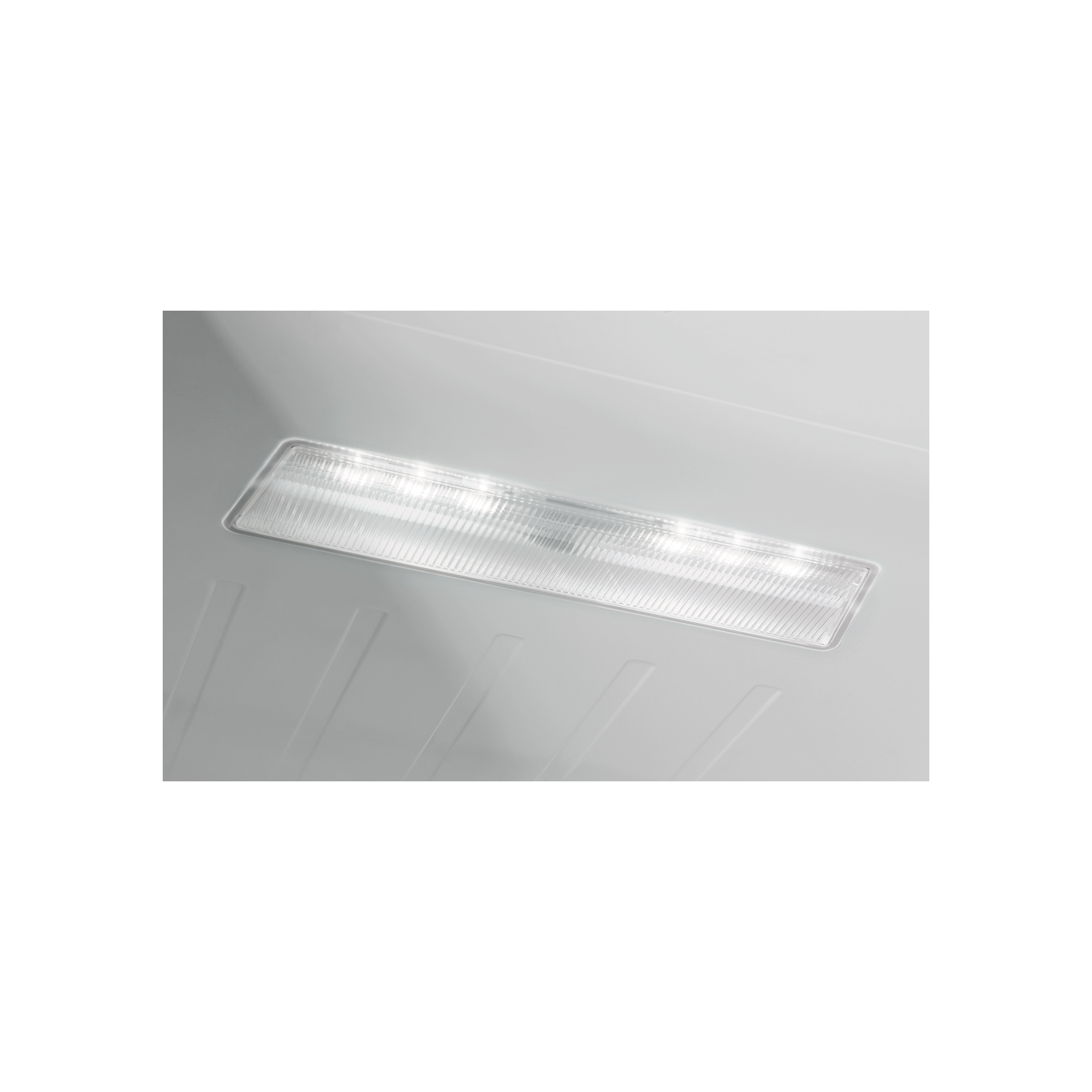 Una tira de luz rectangular iluminada sobre una superficie blanca con ranuras.