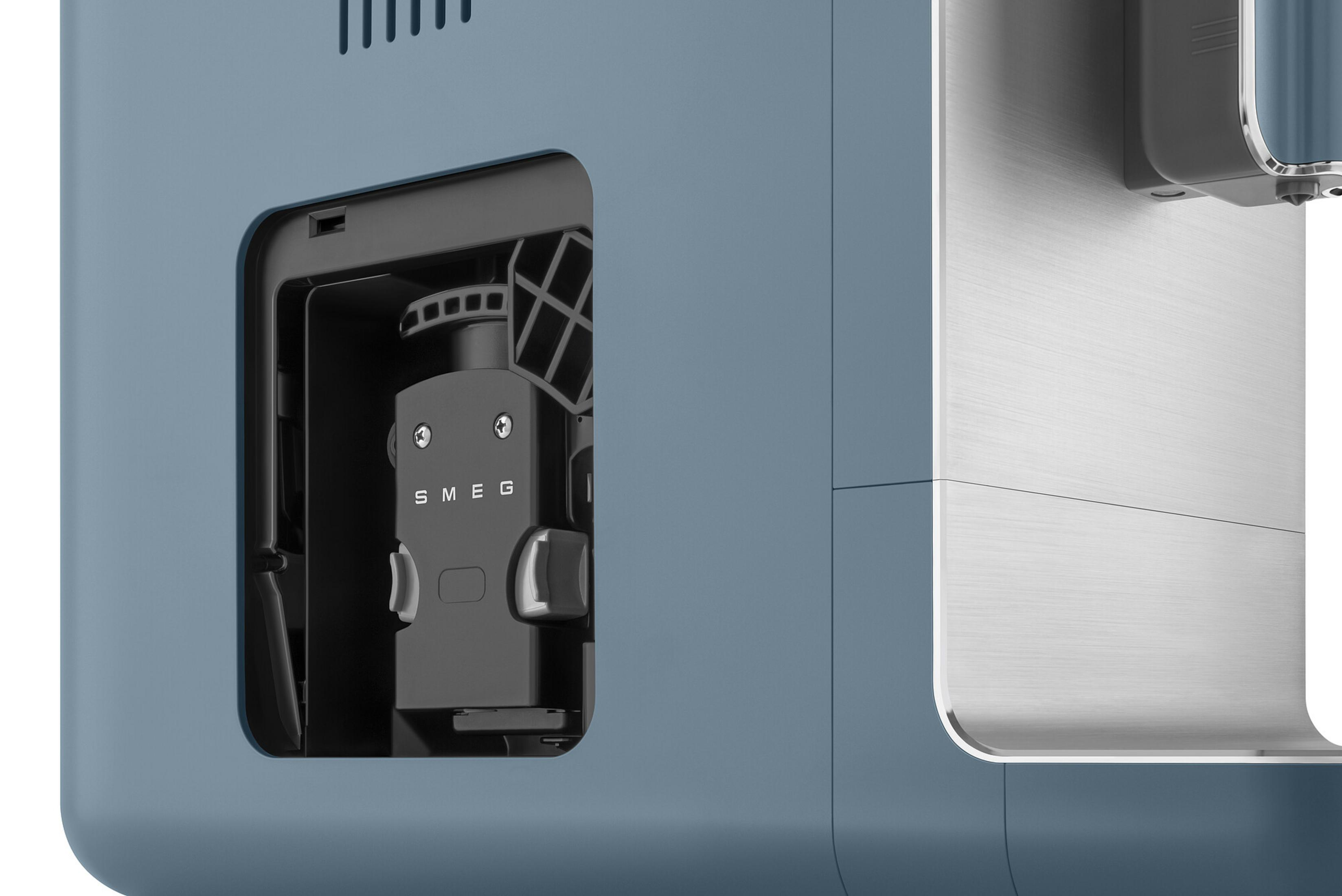 Primer plano de una máquina azul con compartimento abierto que revela un componente SMEG.