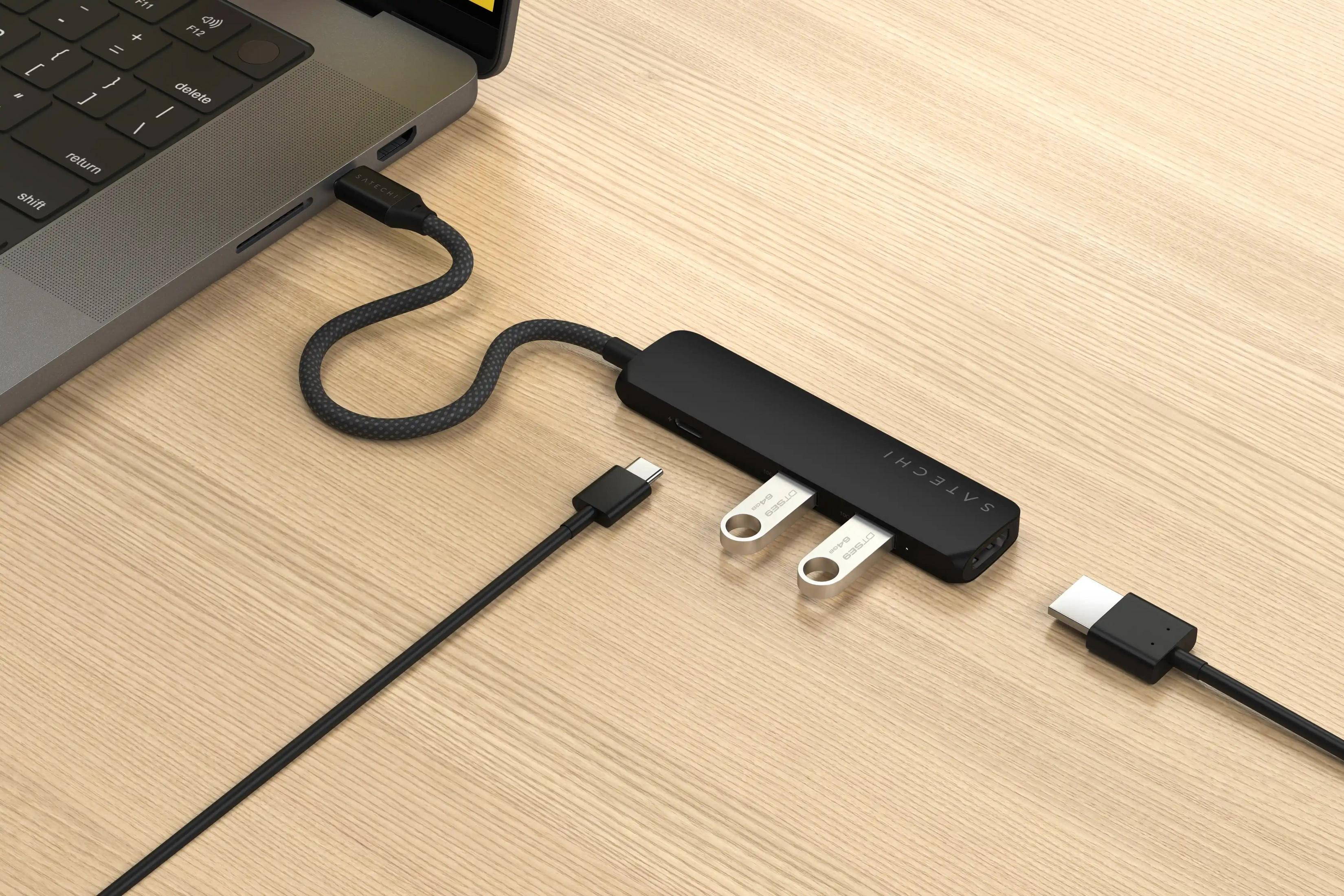 Ein schwarzer USB-C-Hub mit zwei eingesteckten USB-Sticks ist an einem Laptop angeschlossen.