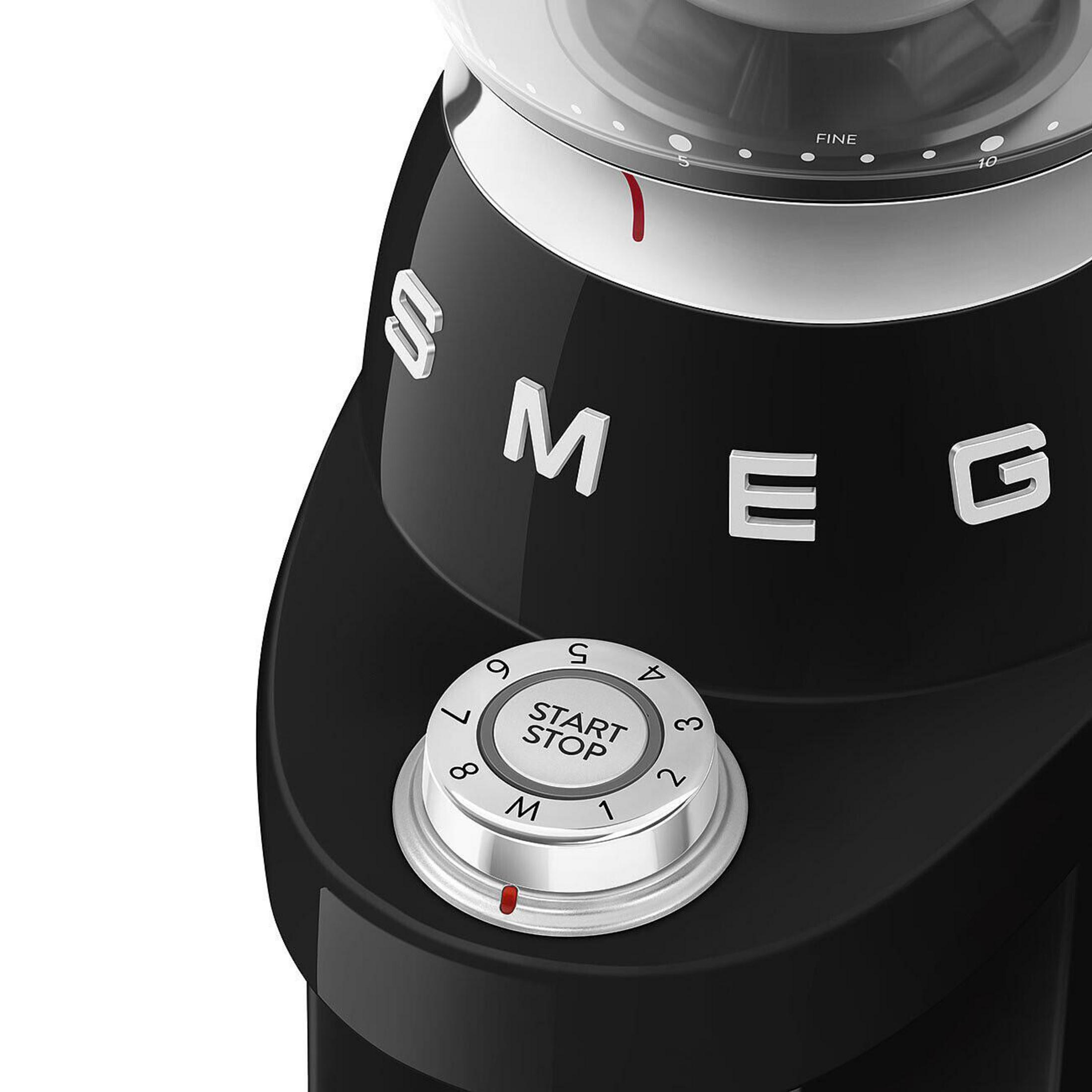 Molinillo de café SMEG negro con dial plateado y ajuste fino.