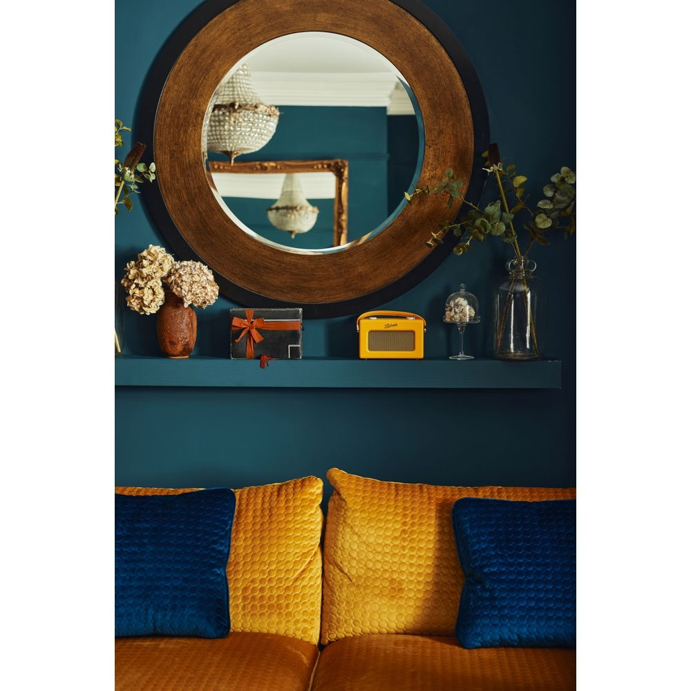 Półka z przedmiotami dekoracyjnymi, w tym wazon, prezent, radio i butelka.