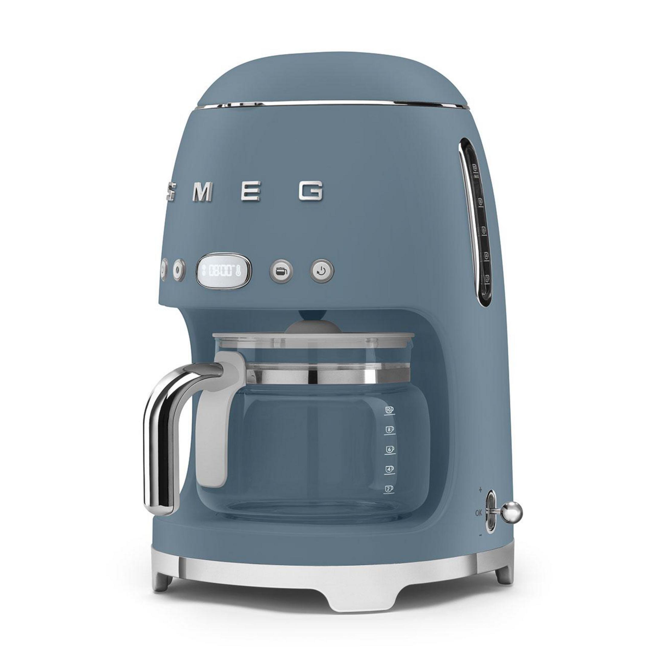 Cam sürahi ve dijital saatli mavi Smeg kahve makinesi. Gümüş vurgular.