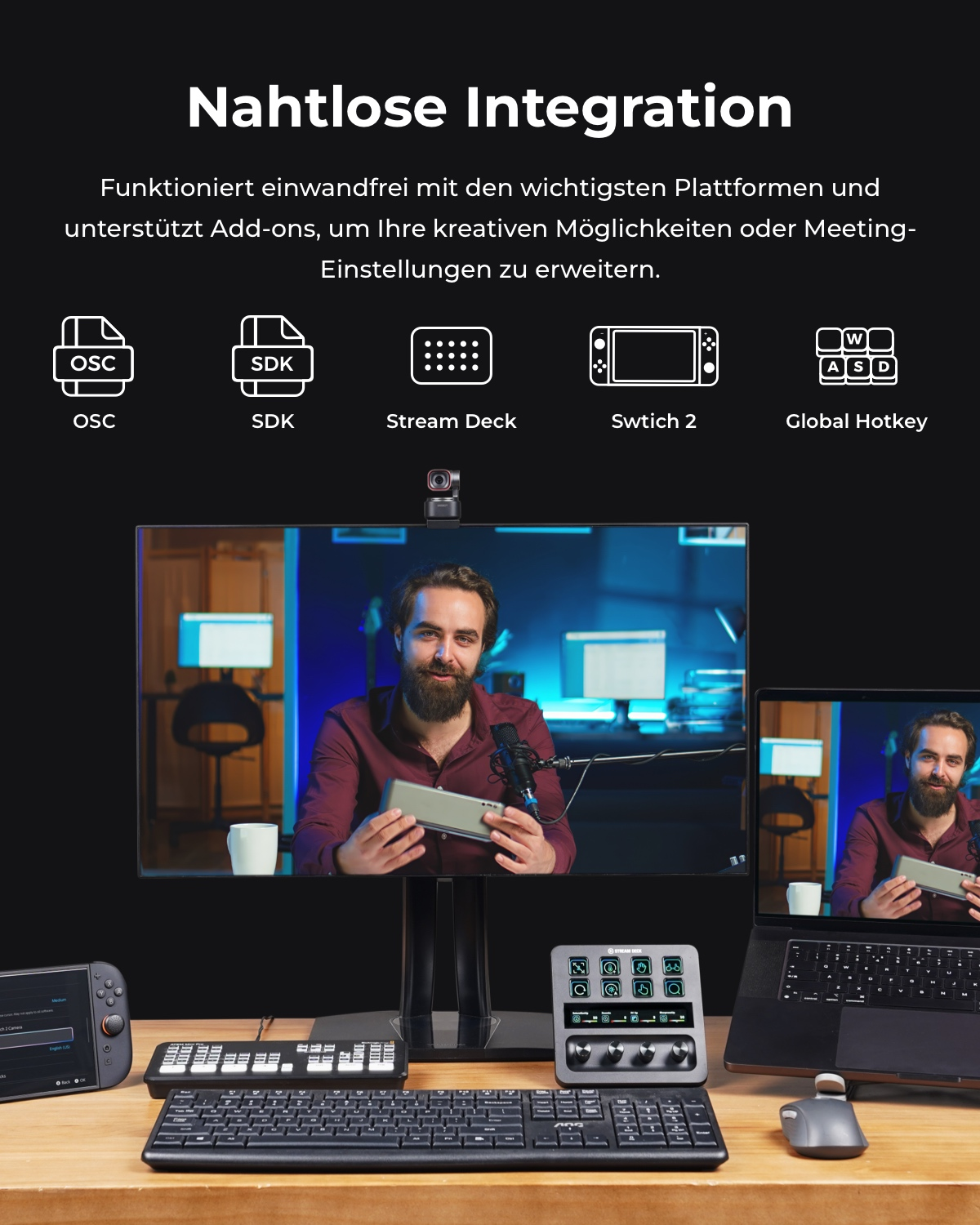 Ein Mann hält ein Gerät vor einem Monitor. Daneben sind Tastaturen und ein Laptop.