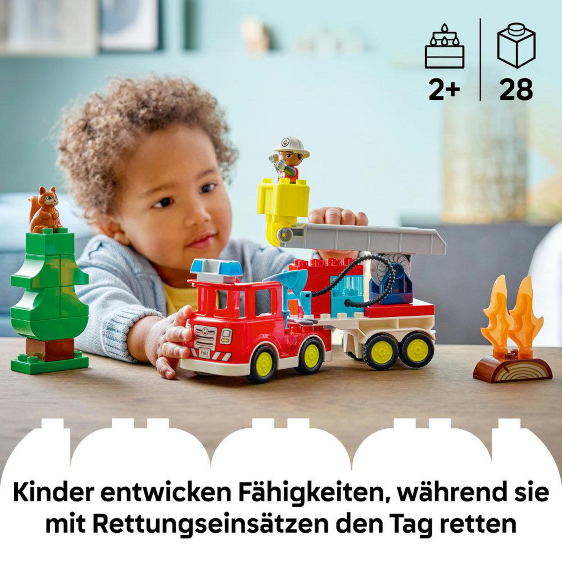 Dziecko bawi się czerwonym wozem strażackim, drzewem z wiewiórką i płomieniami.