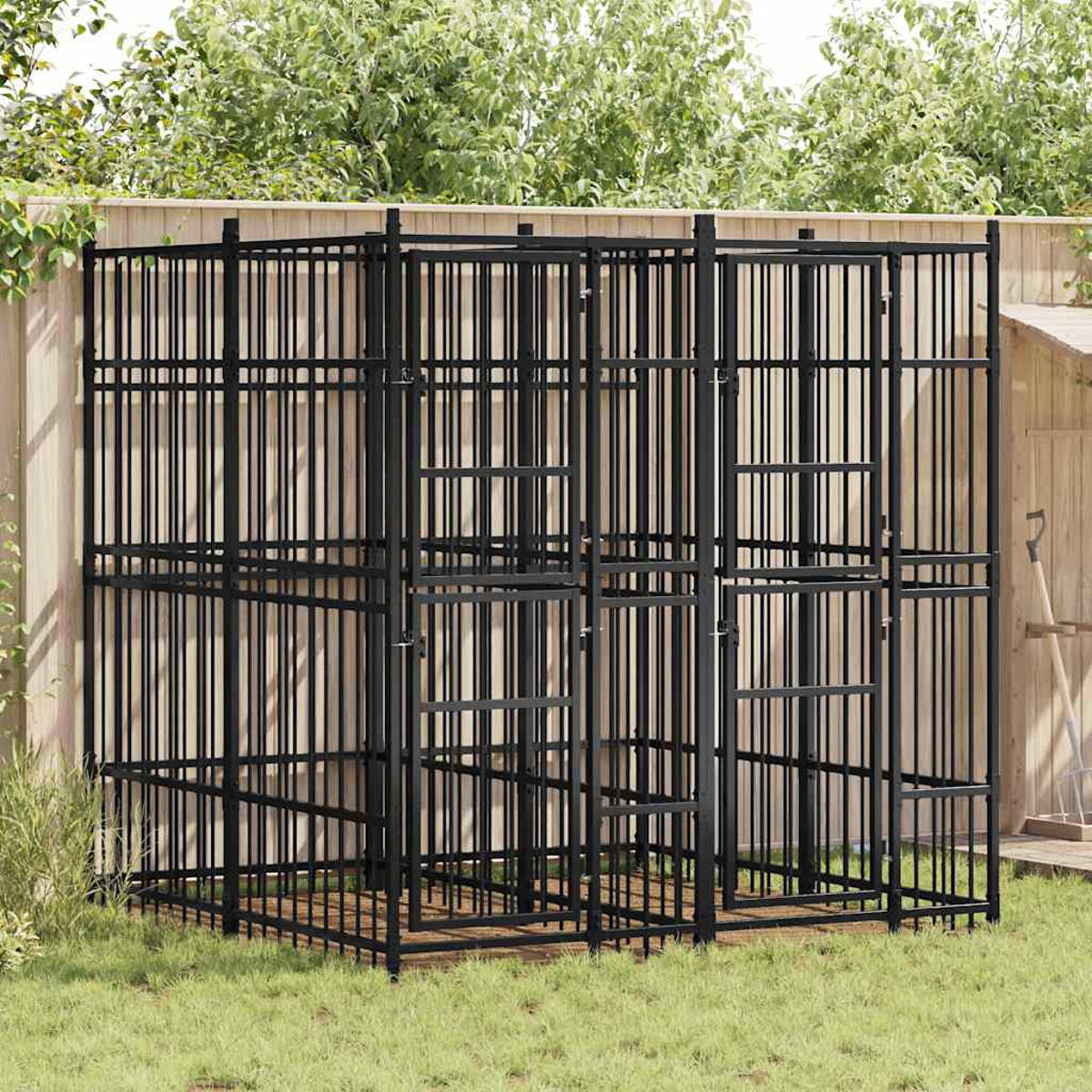Ein großer, schwarzer Metallkäfig mit mehreren Abschnitten steht im Gras.