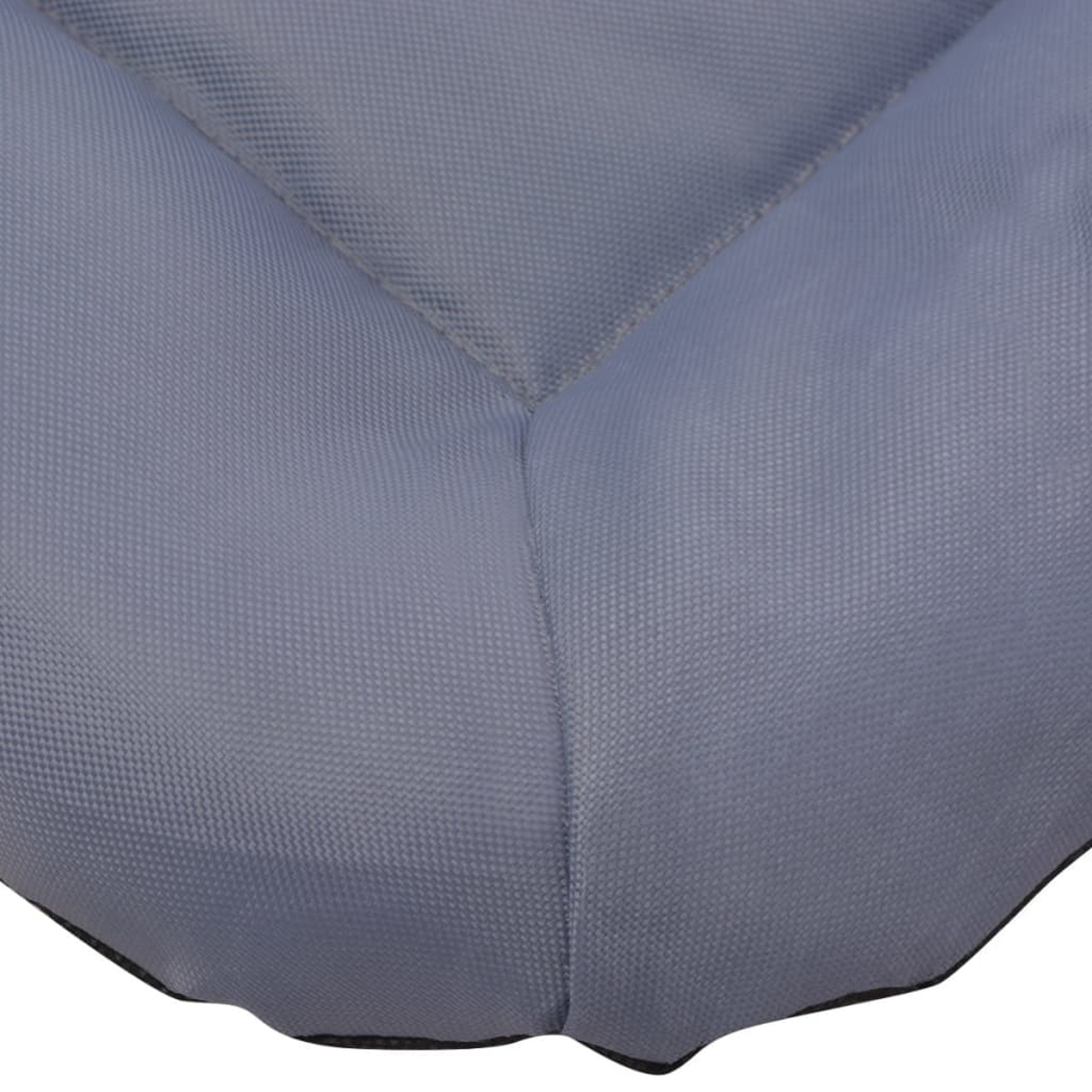 Graues, gestepptes Kissen mit sichtbaren Nähten. Nahaufnahme des Stoffes.
