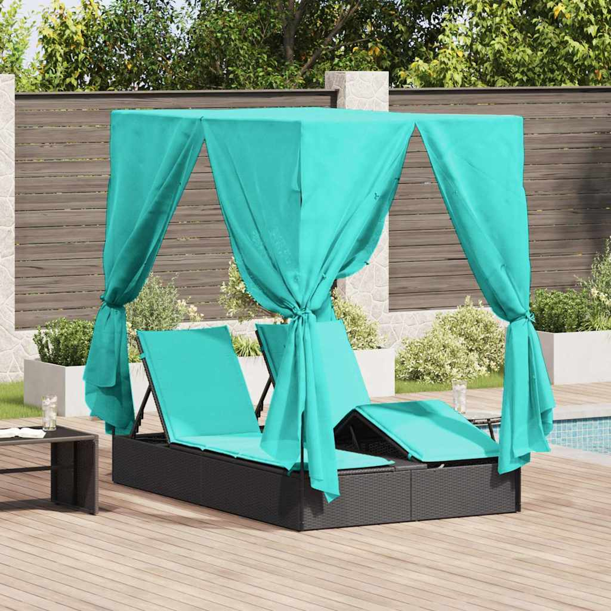 Zwei Daybeds mit türkisfarbenen Kissen und türkisfarbenen Baldachinen auf einer Holzterrasse am Pool.