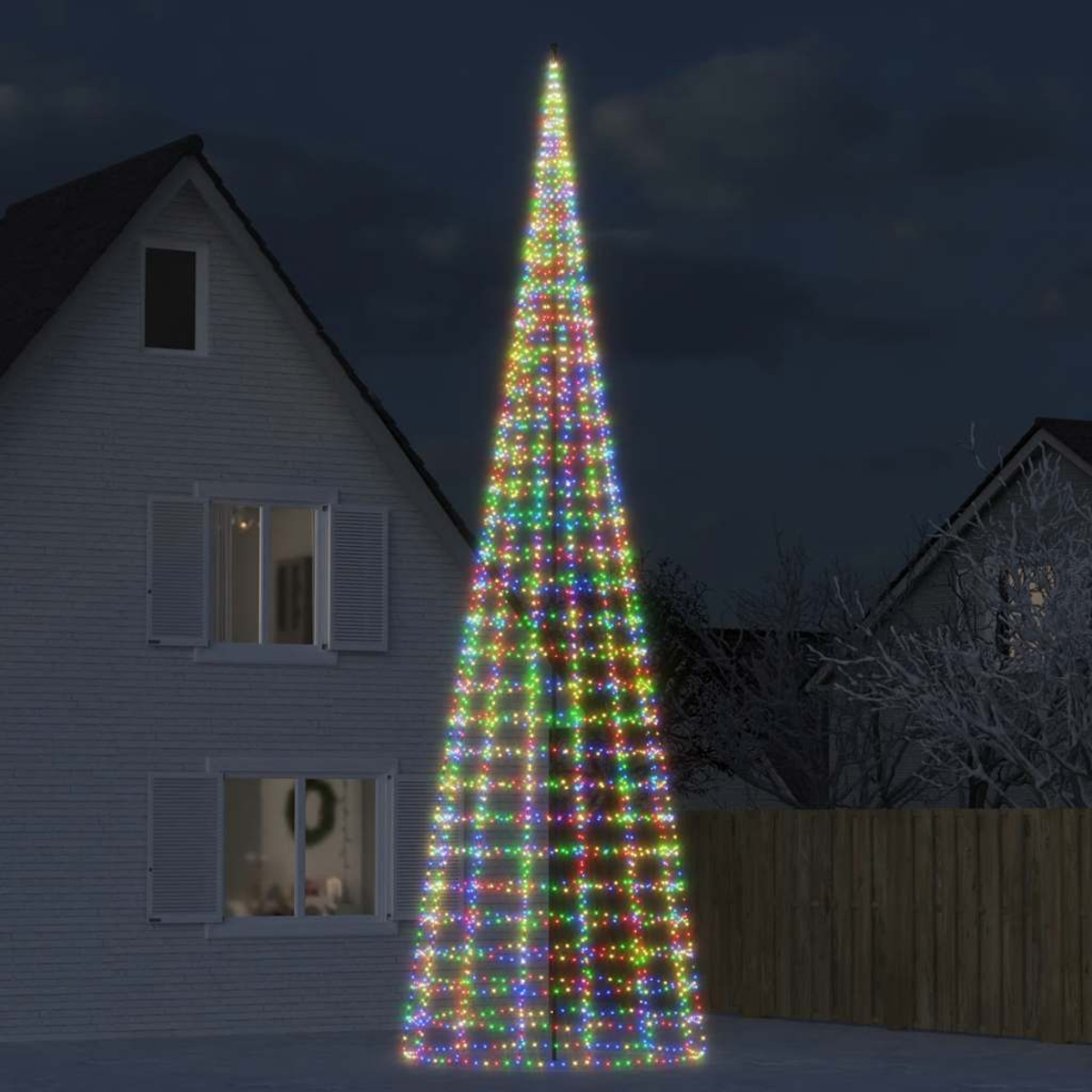 Ein konischer Weihnachtsbaum, geschmückt mit bunten Lichtern, steht vor einem Haus.