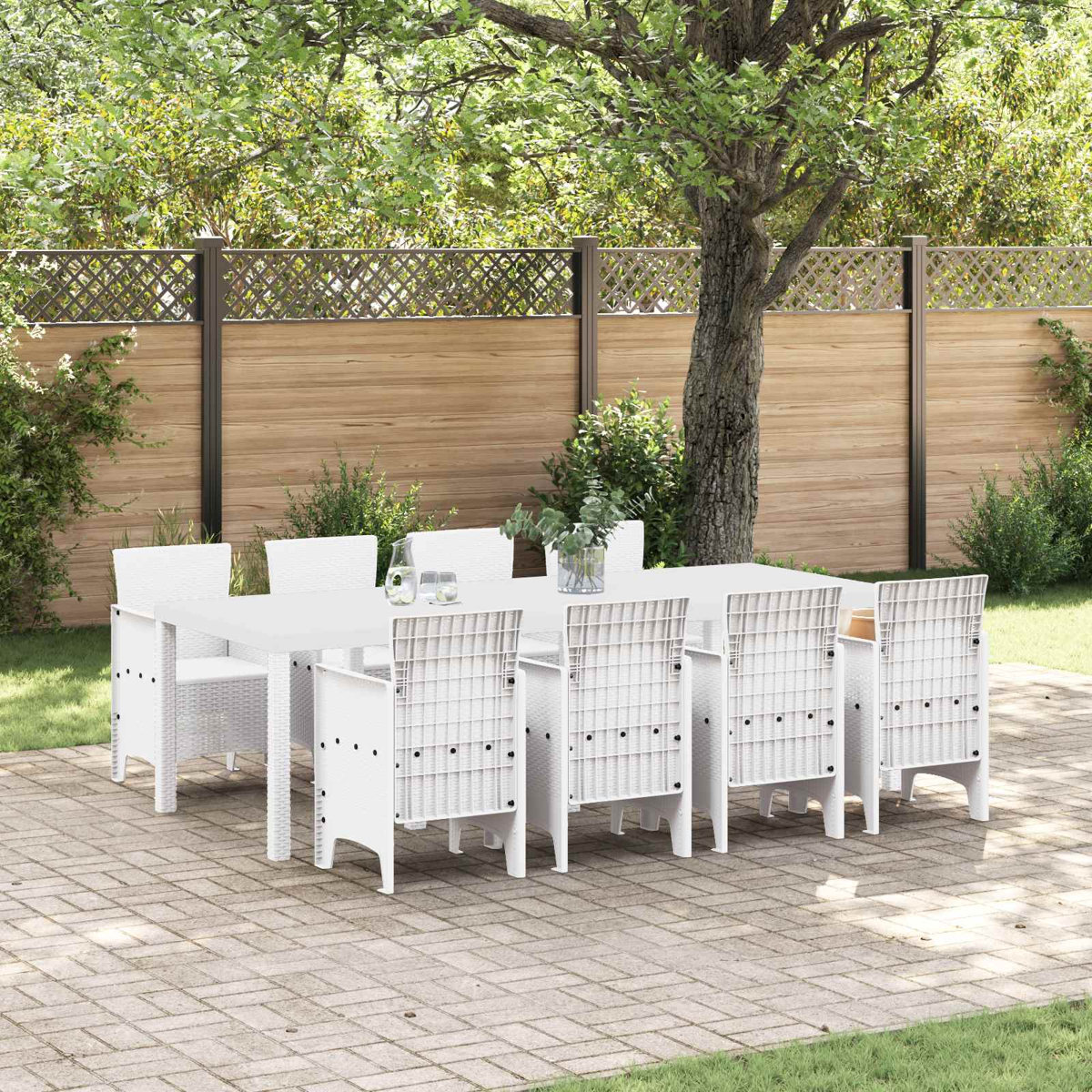 Un conjunto de muebles de exterior blancos con mesa y ocho sillas en un patio pavimentado.