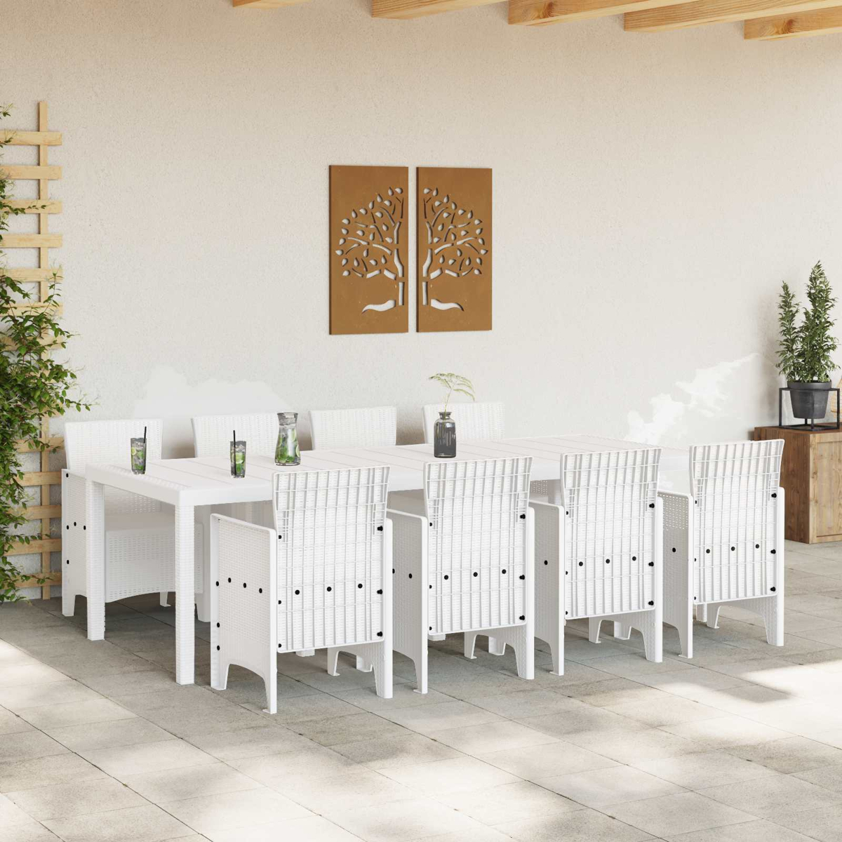 Conjunto de comedor de ratán blanco con ocho sillas en un patio, con plantas y arte de pared.