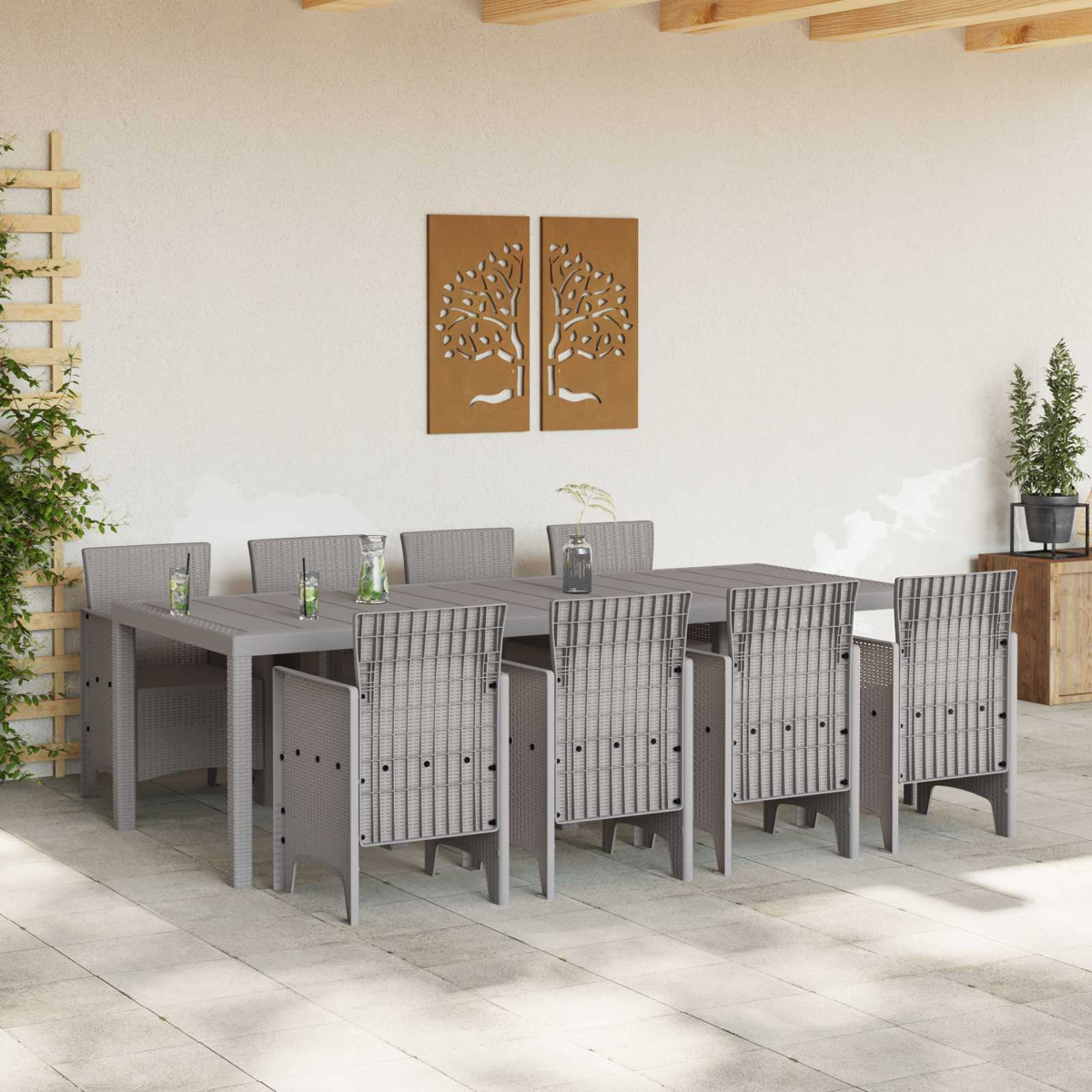 Grauer Tisch mit acht Stühlen im Freien, dekoriert mit Bäumen an der Wand.