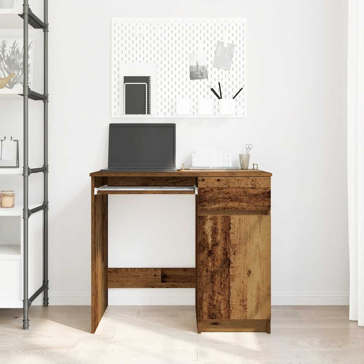 Ein Holztisch mit einem Laptop, Tastatur und Schublade vor einem weißen Board.