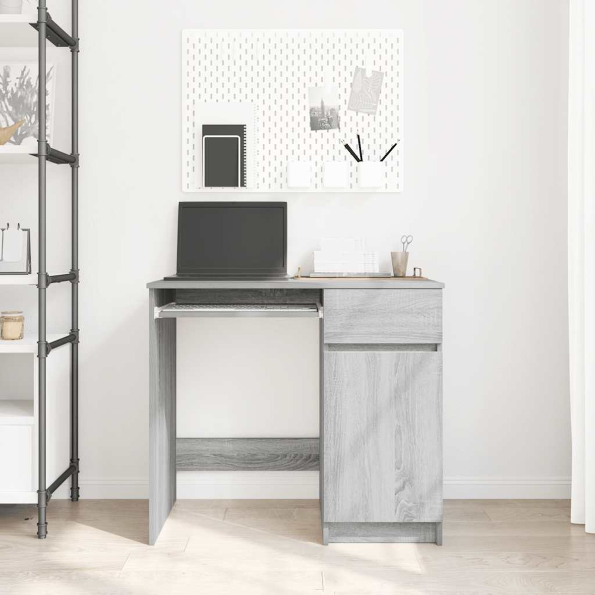 Ein grauer Schreibtisch mit ausziehbarer Tastatur, Laptop, Schublade und Schrank.