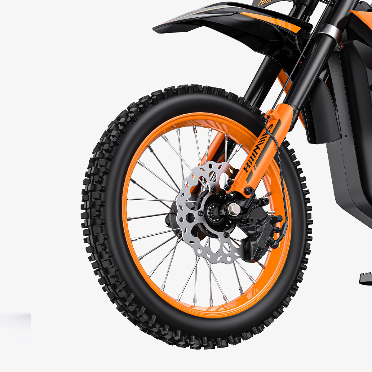 Zbliżenie przedniego koła i pomarańczowego zawieszenia motocykla terenowego.