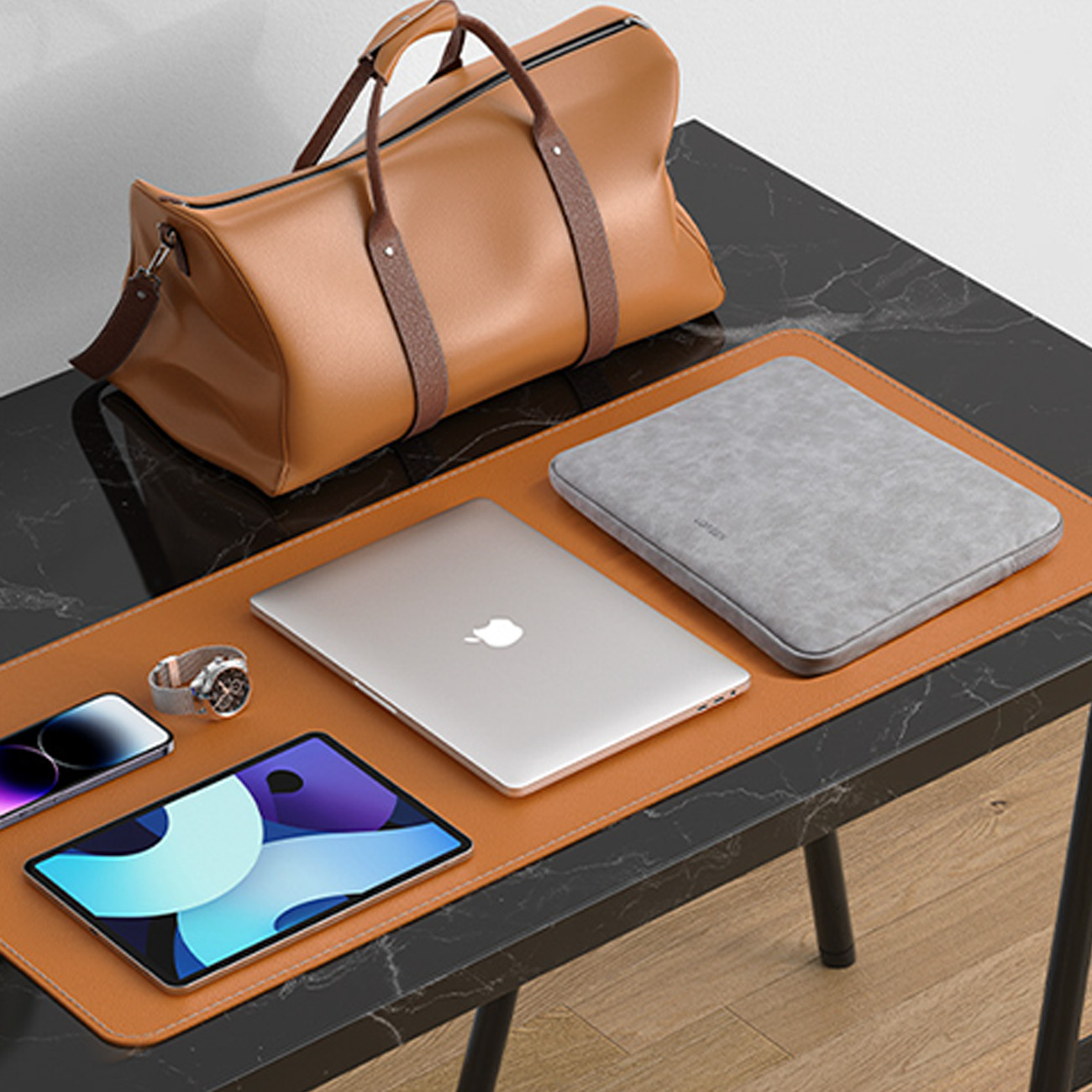 Brązowa torba podróżna na czarnym marmurowym biurku z laptopem, tabletem, telefonem i zegarkiem.