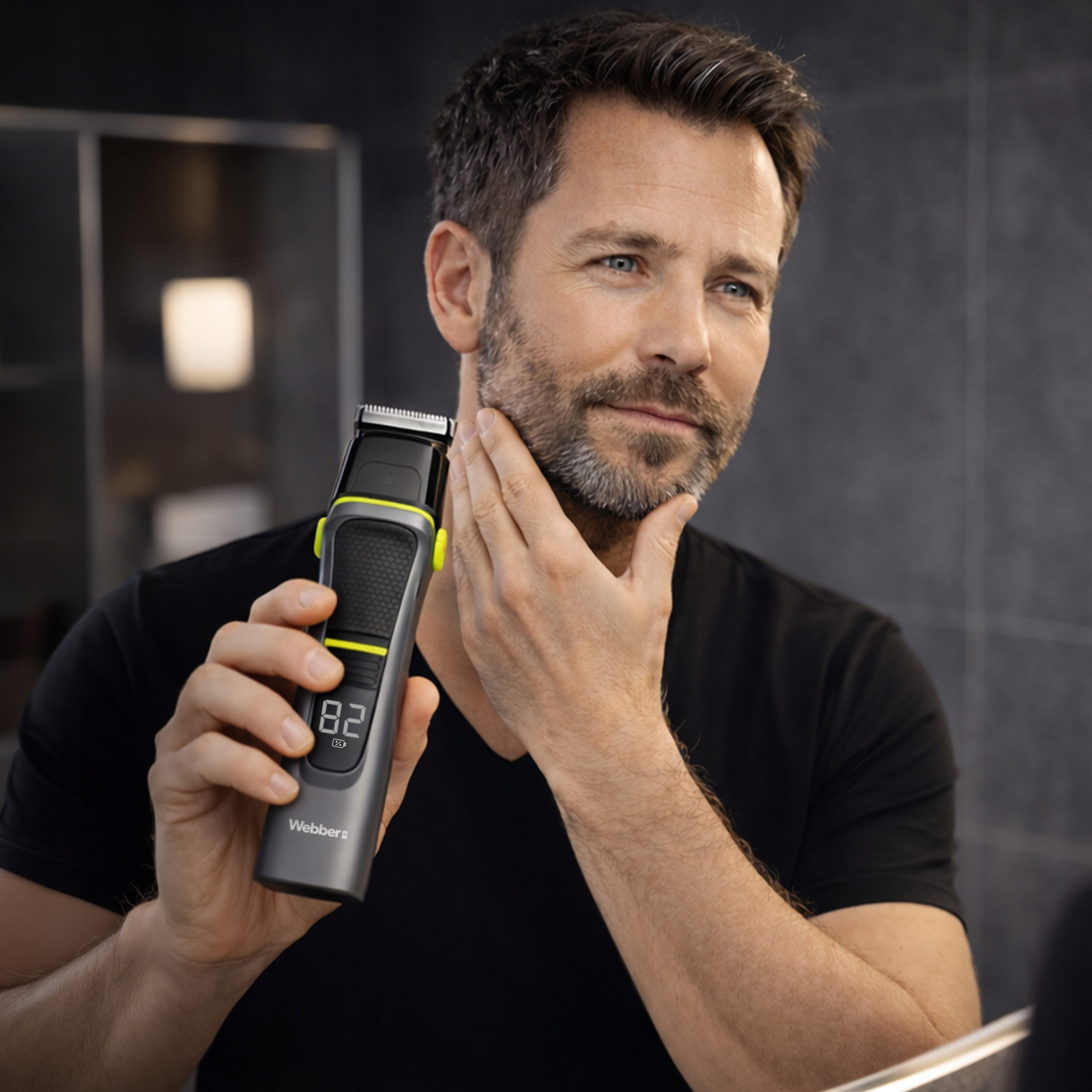 Mężczyzna z brodą trzyma trymer i dotyka twarzy.