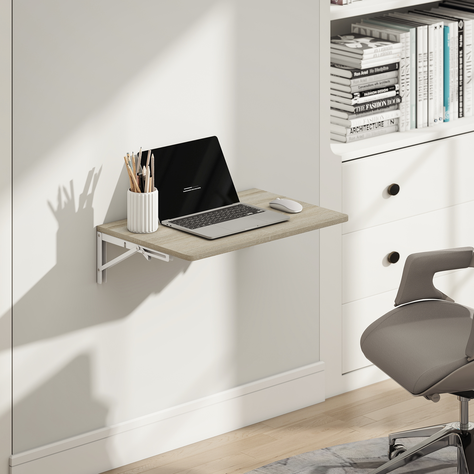 Ein Wandklapptisch mit Laptop, Stiften und Maus vor einem Bücherregal.