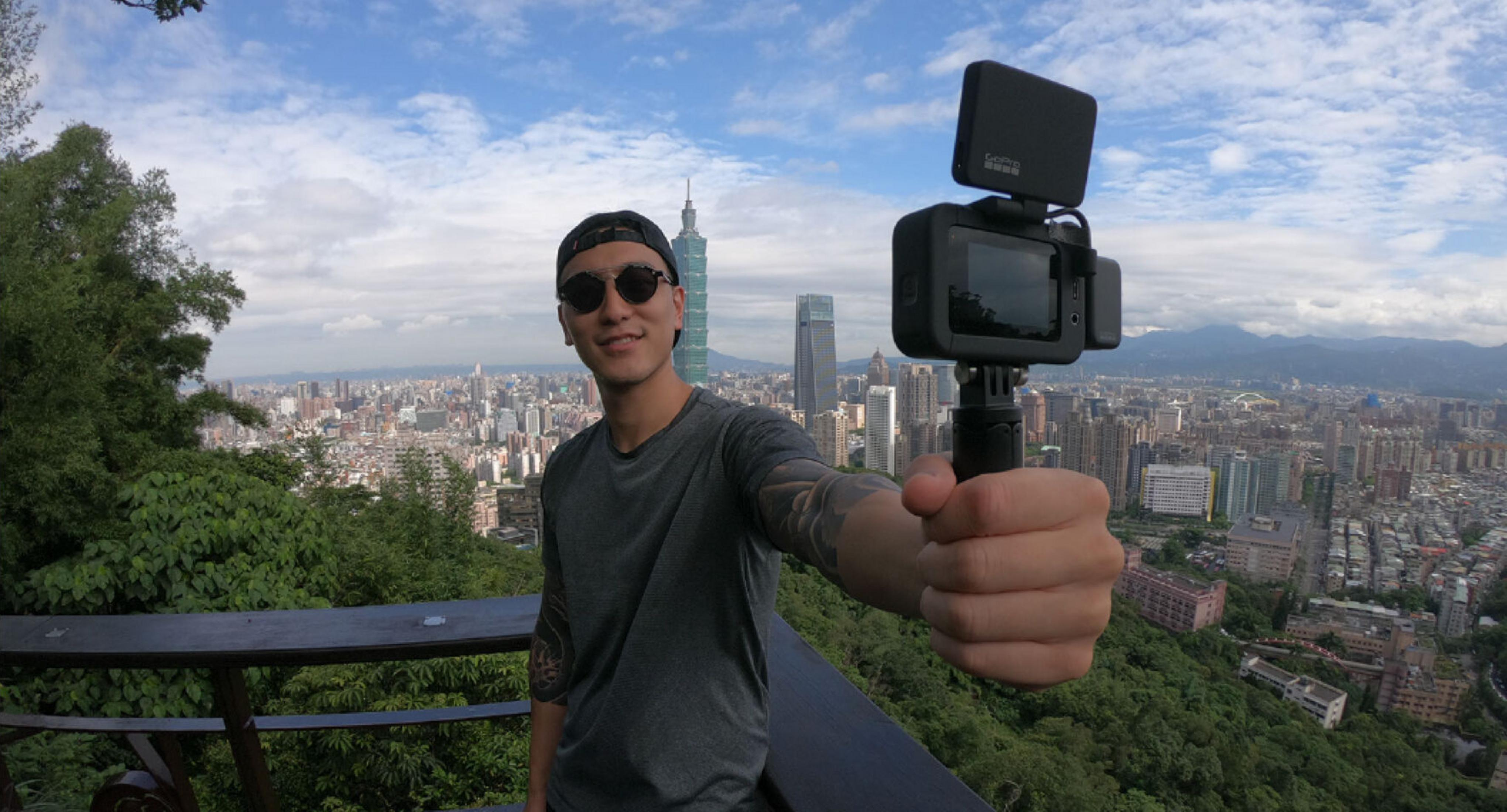 Uomo tiene macchina fotografica con skyline della città.