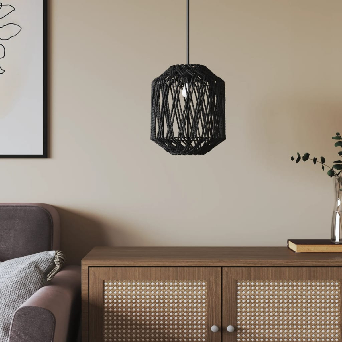 Ein schwarzer Pendelleuchter aus Seil hängt über einem Holzschrank mit Rattanfronten.