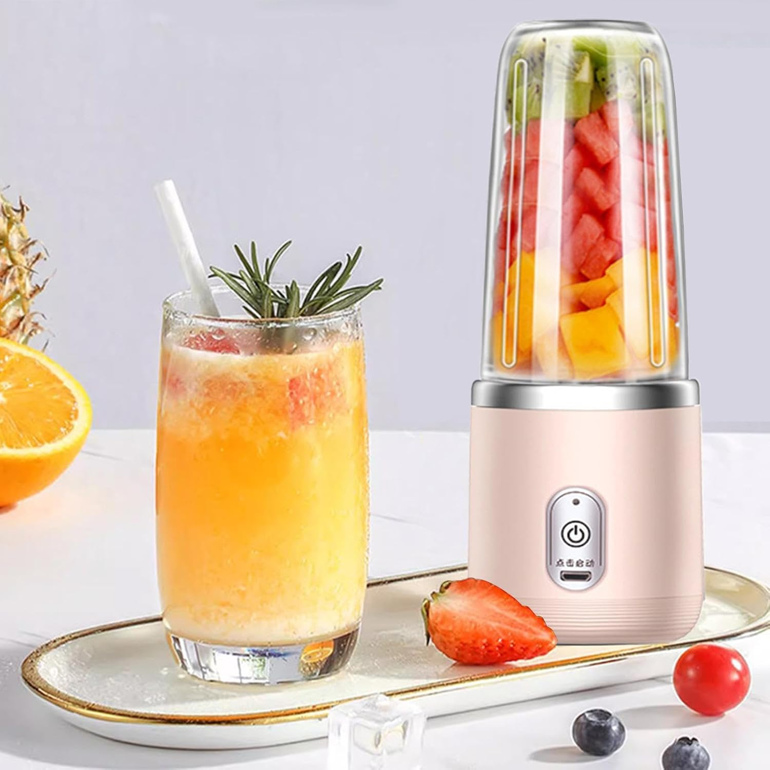 Ein Mixer mit Früchten, daneben ein Glas Saft und Beeren.