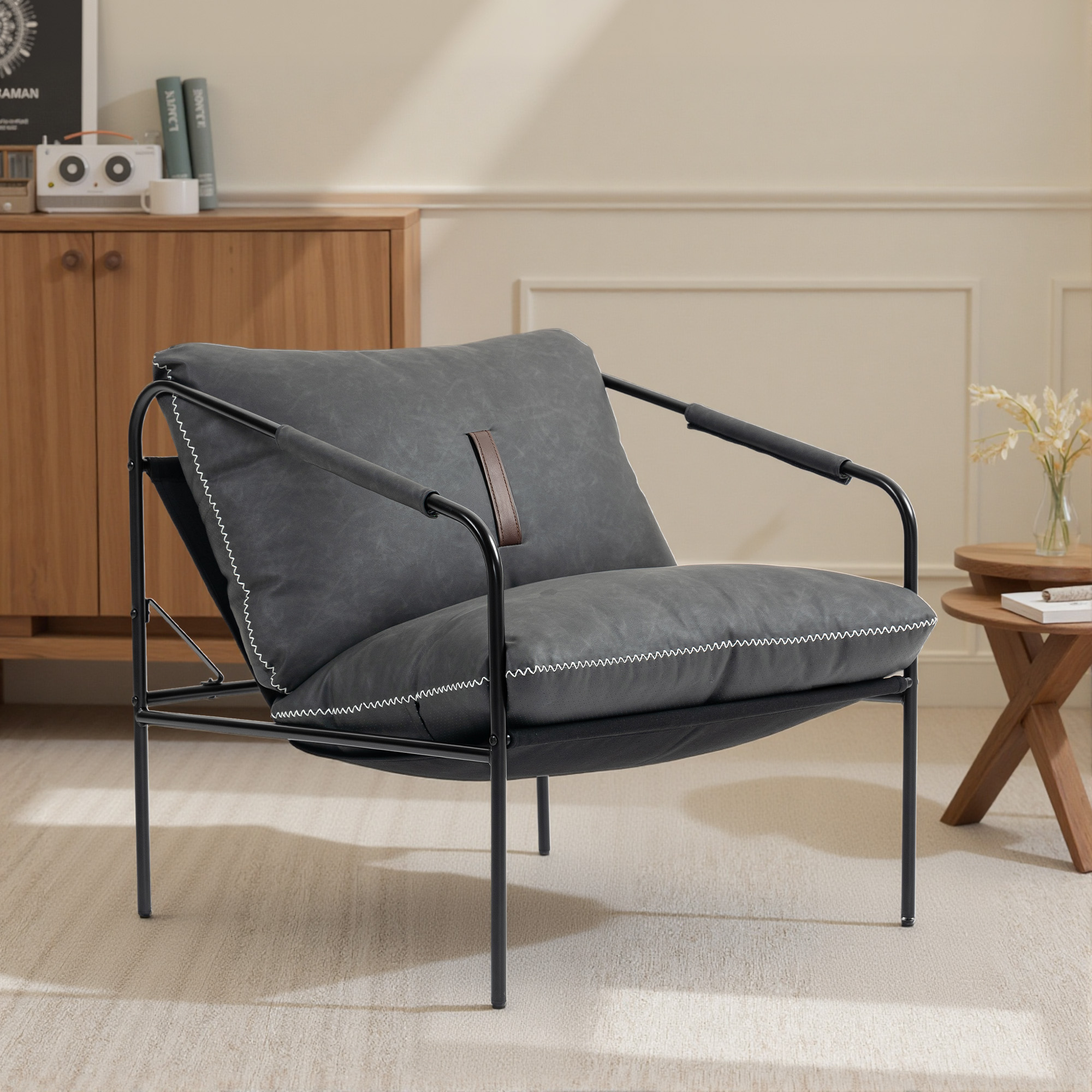 Un sillón oscuro con estructura de metal negro se asienta sobre una alfombra beige.