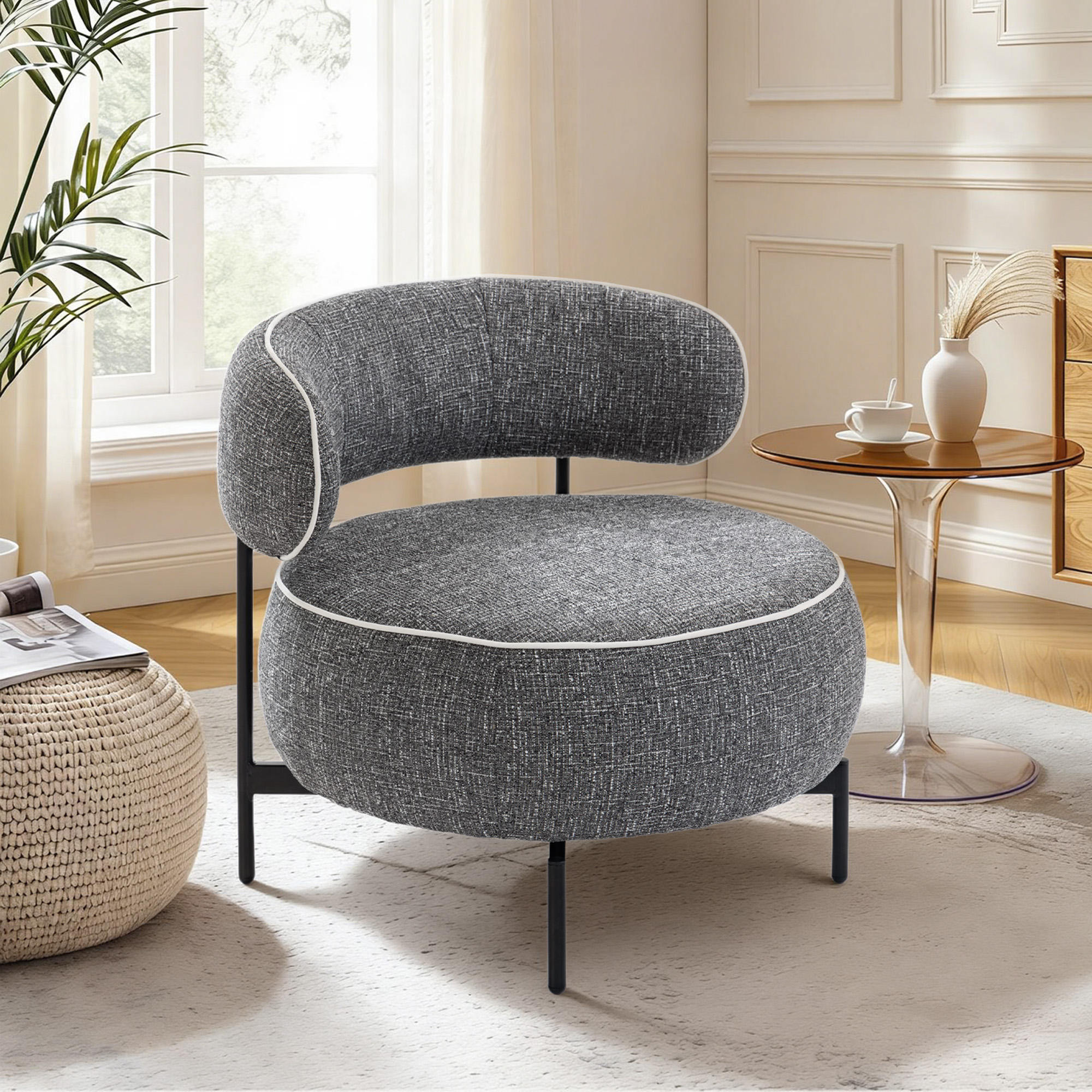 Un sillón gris con ribete blanco se sienta sobre una alfombra junto a una mesa auxiliar.