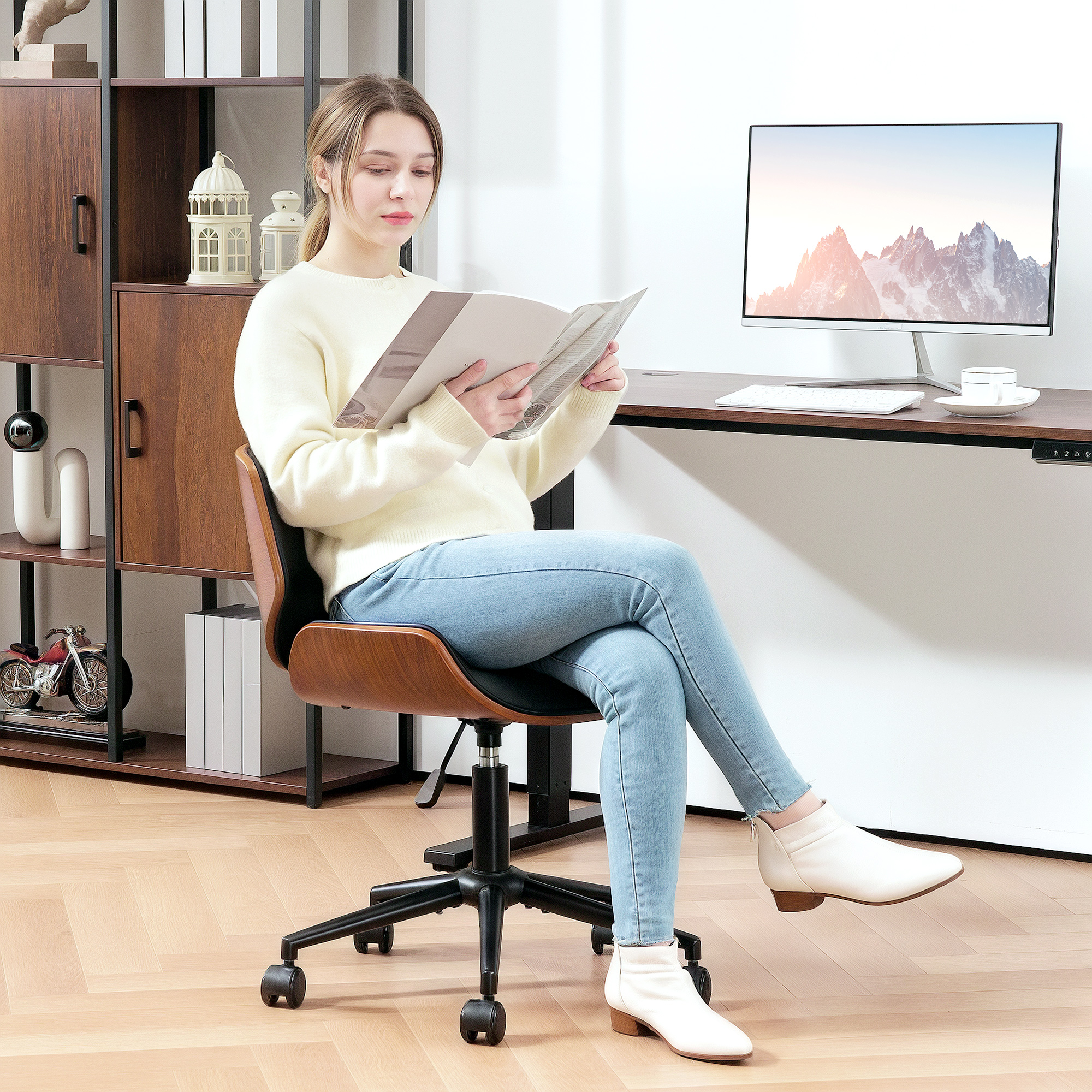 Una mujer lee una revista sentada en una silla de oficina.