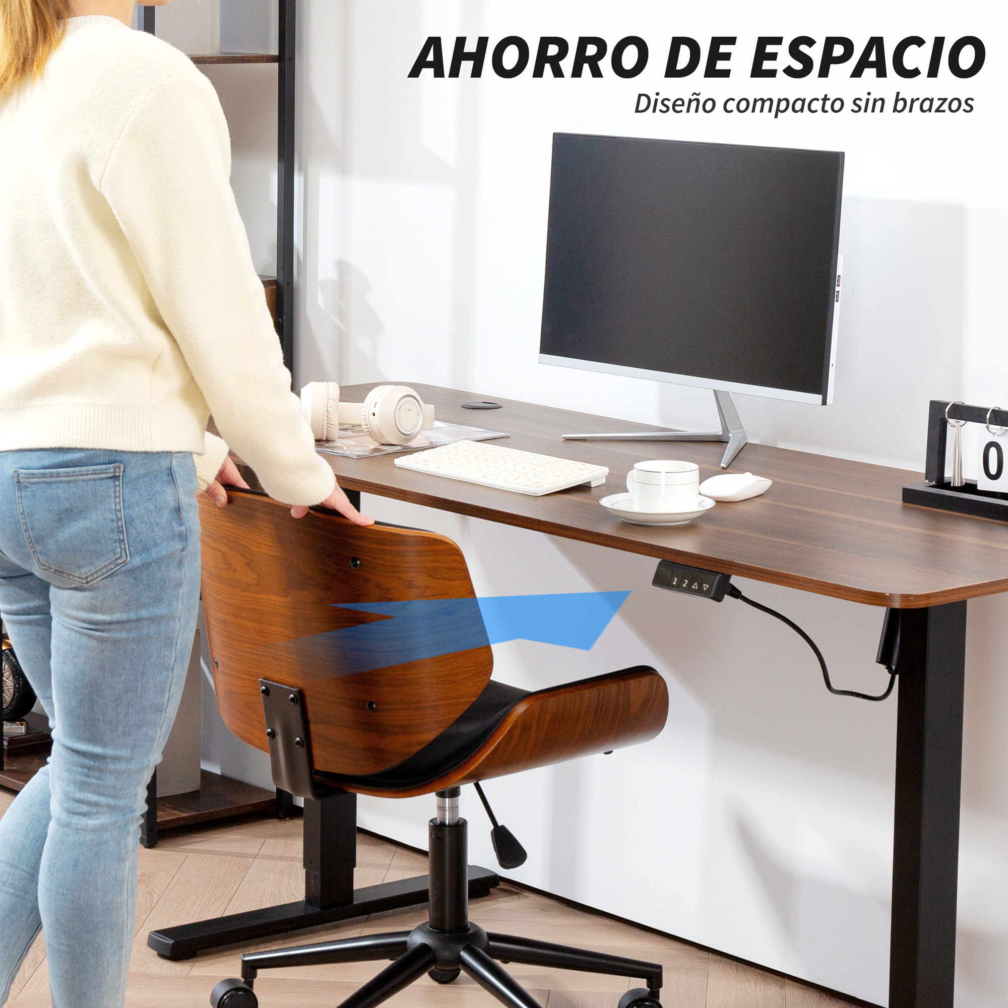 Una persona se para en un escritorio con un monitor, teclado y silla.