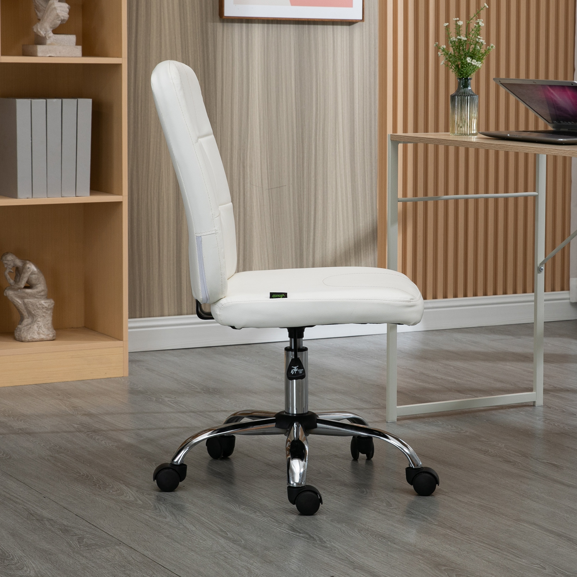 Una silla de oficina blanca con base cromada y ruedas sobre suelo de madera.