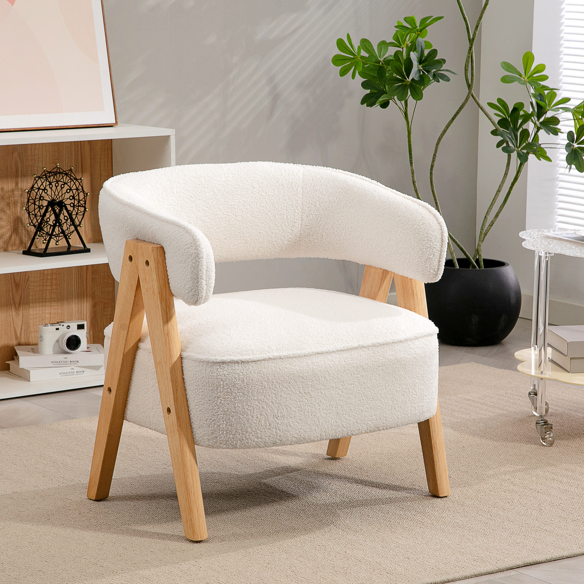 Una silla blanca de peluche con patas de madera sobre una alfombra beige.