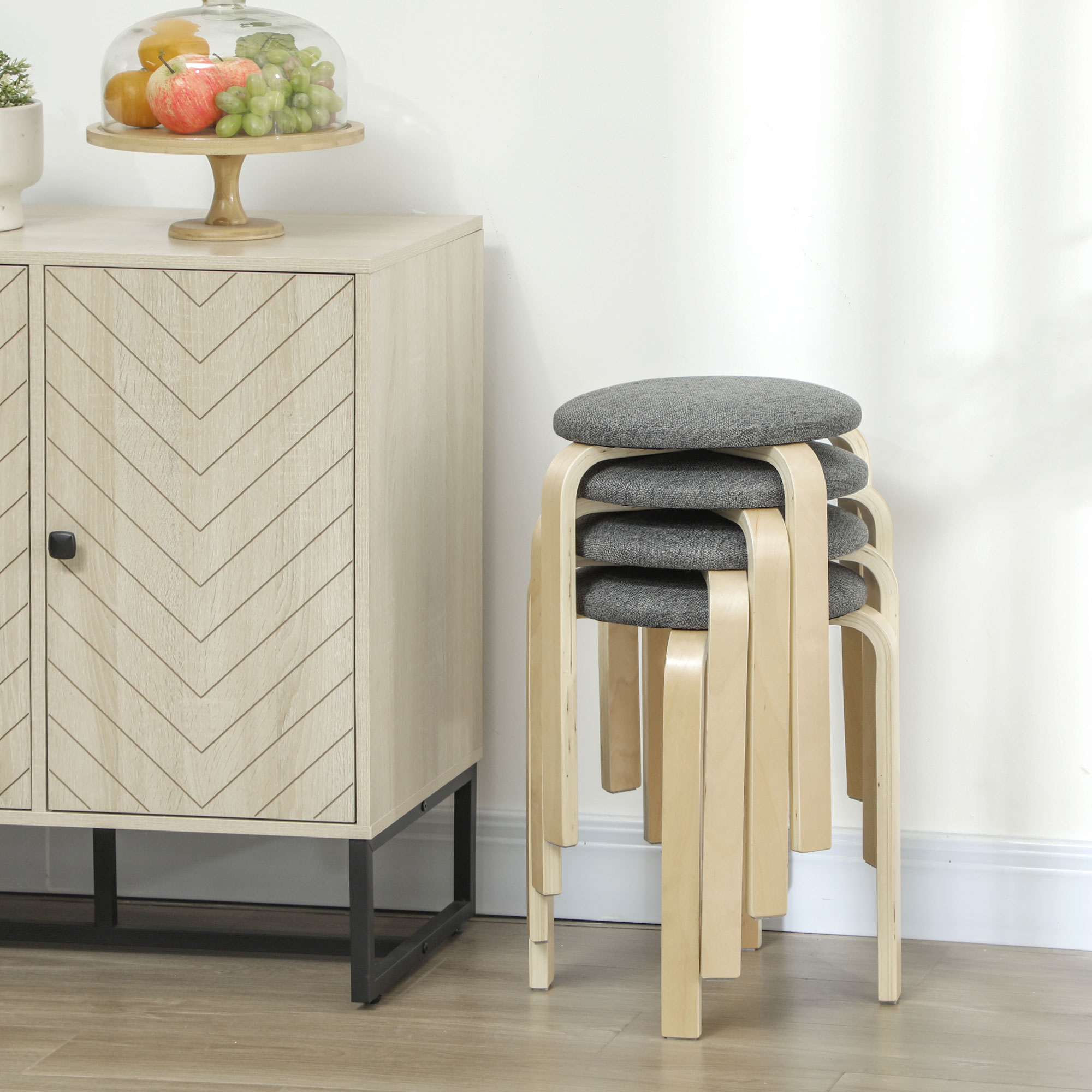 Un armario de madera con diseño de espiga y taburetes apilados con asientos grises.