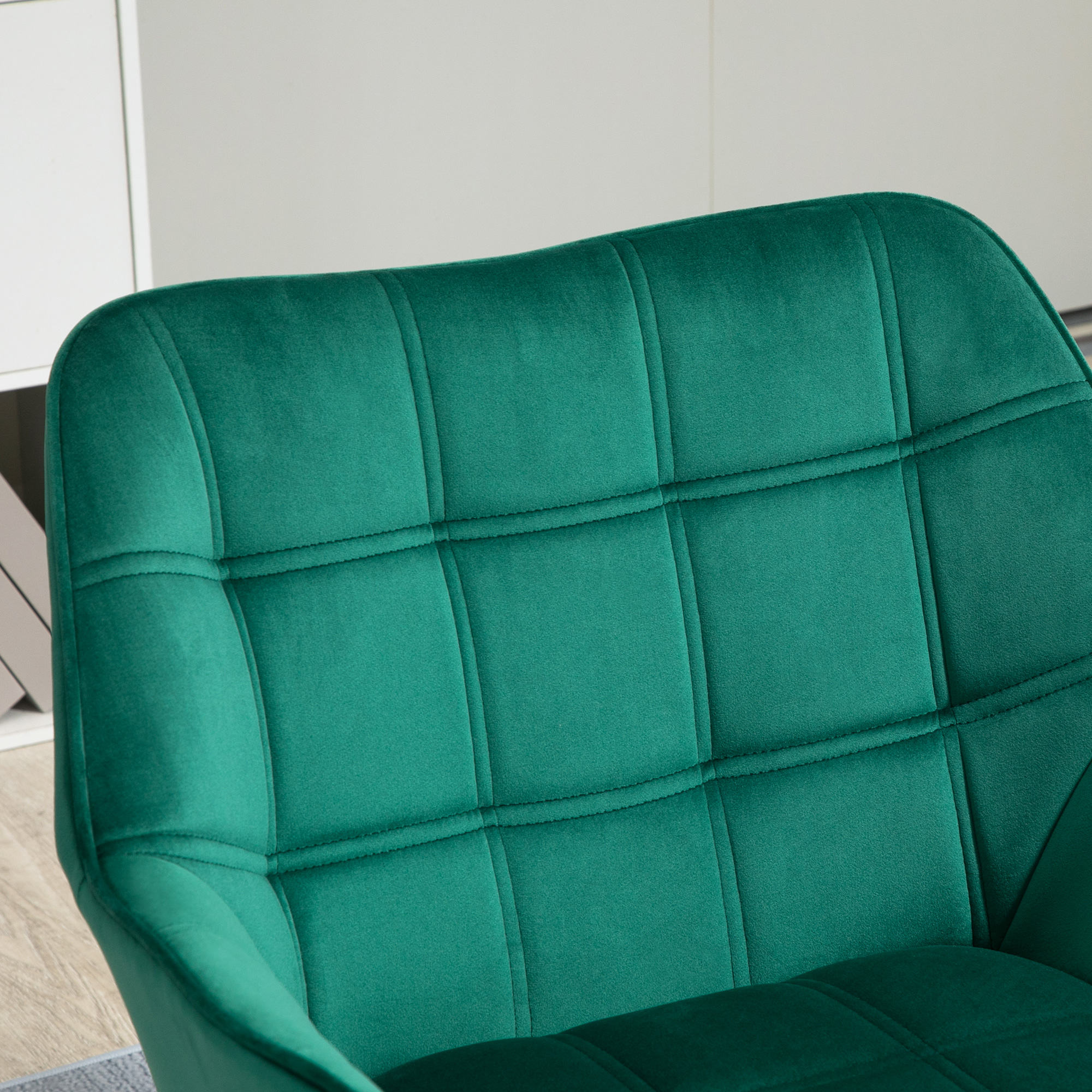 Una silla de terciopelo verde con capitoné de rombos.