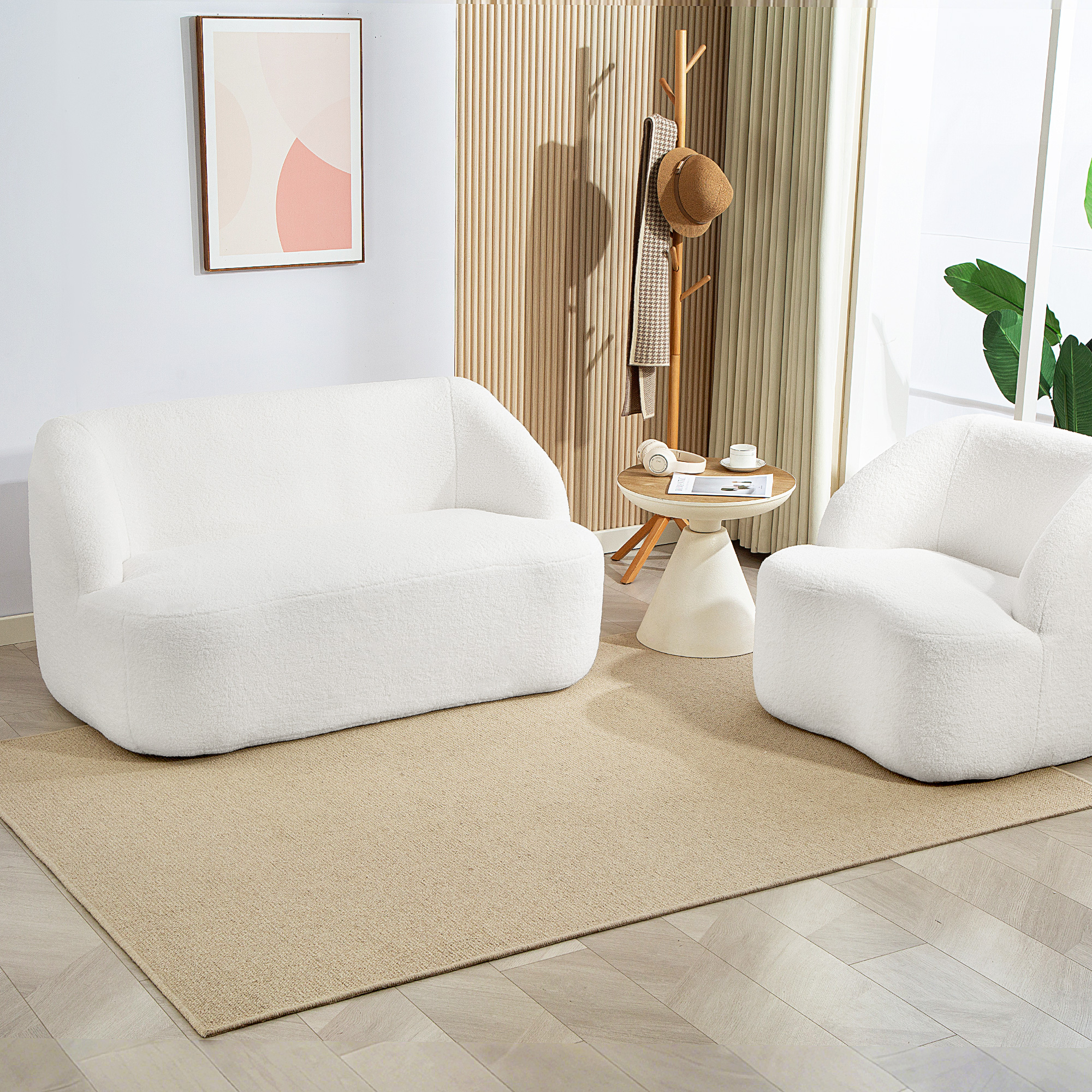 Un sofá y sillón blancos de bouclé sobre una alfombra en una habitación luminosa.