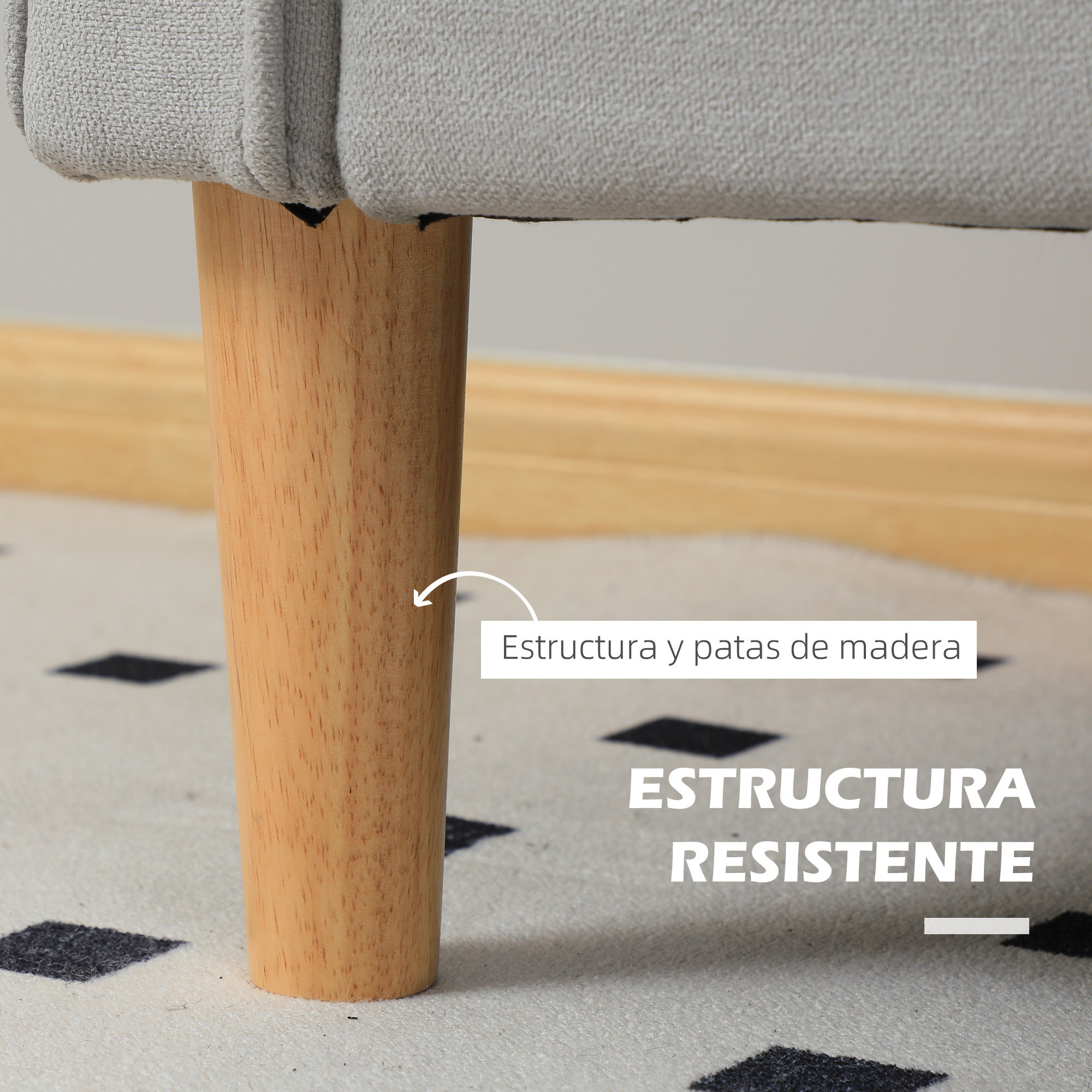 Estructura de mueble tapizado gris con patas de madera cónicas sobre alfombra.