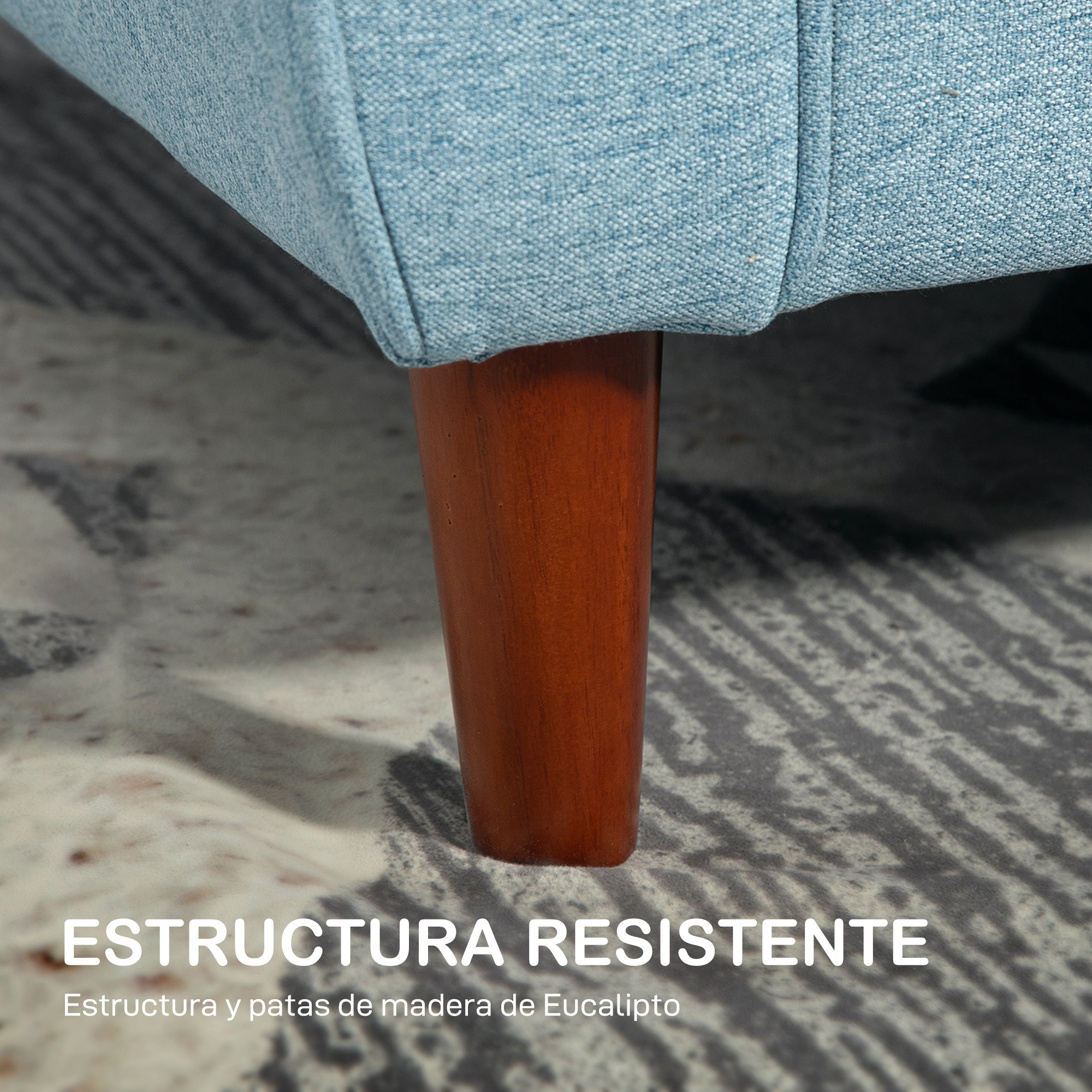 Primer plano de una pata de sofá azul de madera sobre una alfombra estampada.