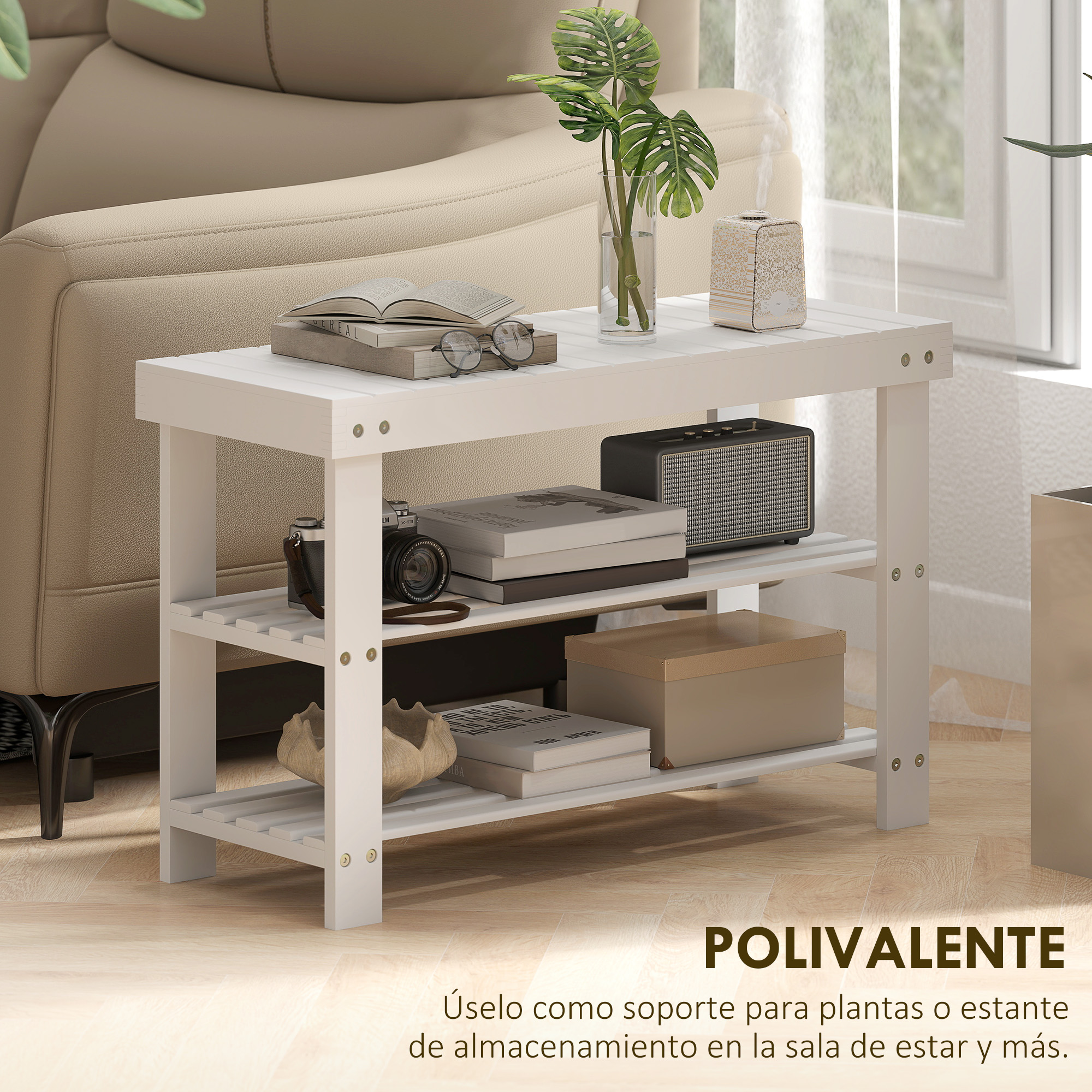 Un estante blanco con libros, cámara, planta y altavoz.