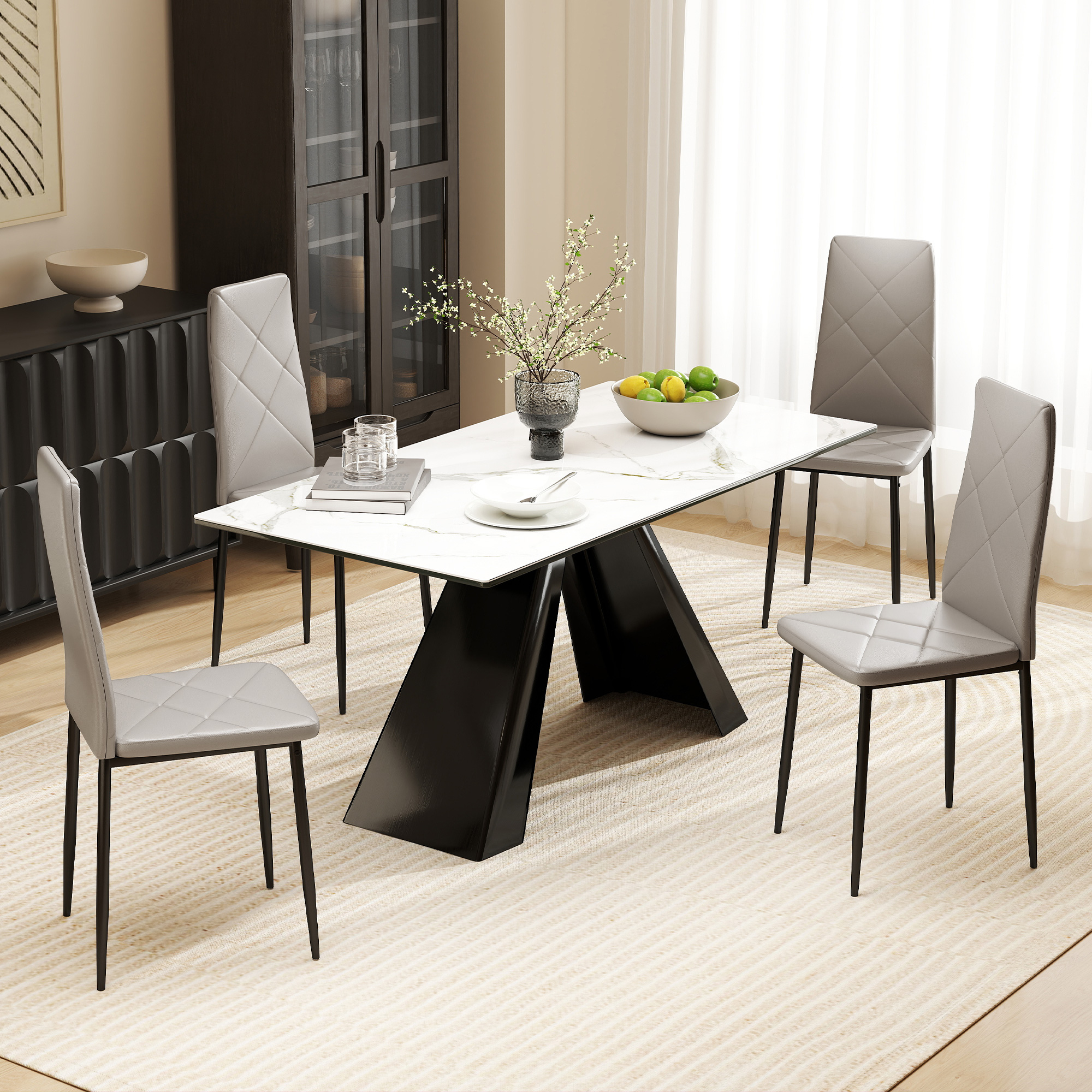 Tavolo da pranzo moderno con piano in marmo e gambe nere, quattro sedie grigie accanto.